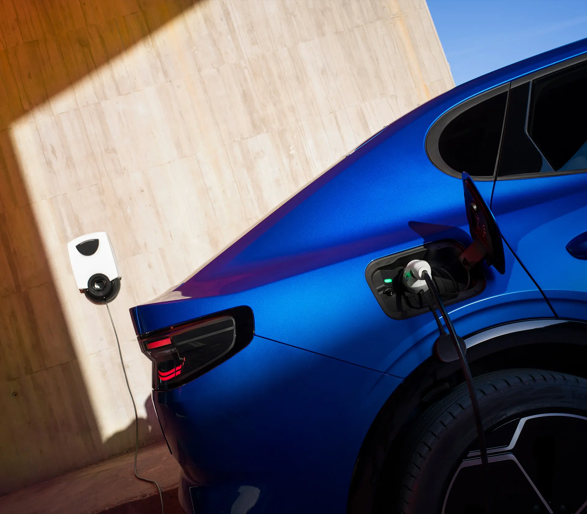 Blauer Capri läd an einer Wallbox