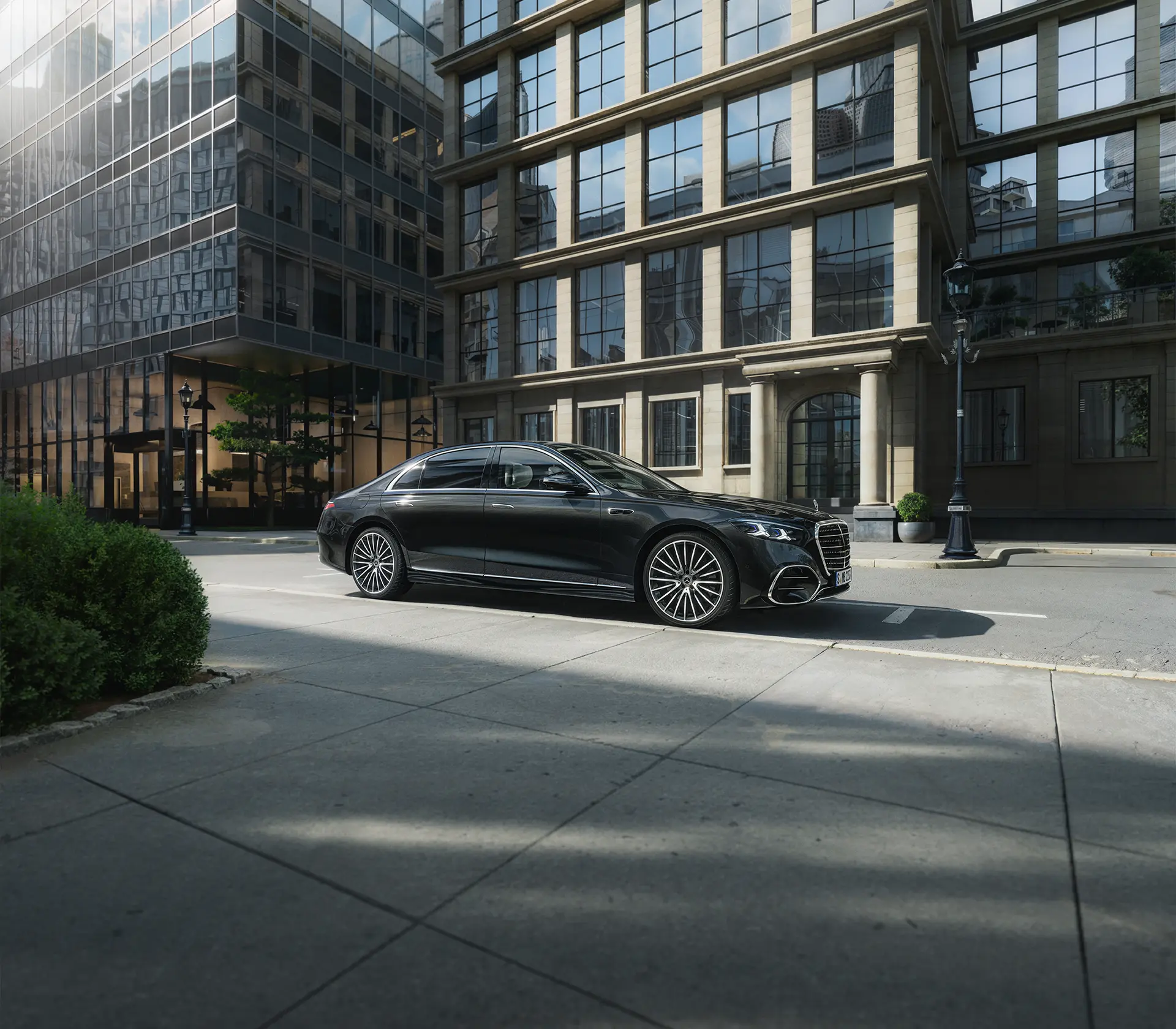 die neue S-Klasse in schwarz am Straßenrand geparkt mit Glasgebäuden im Hintergrund