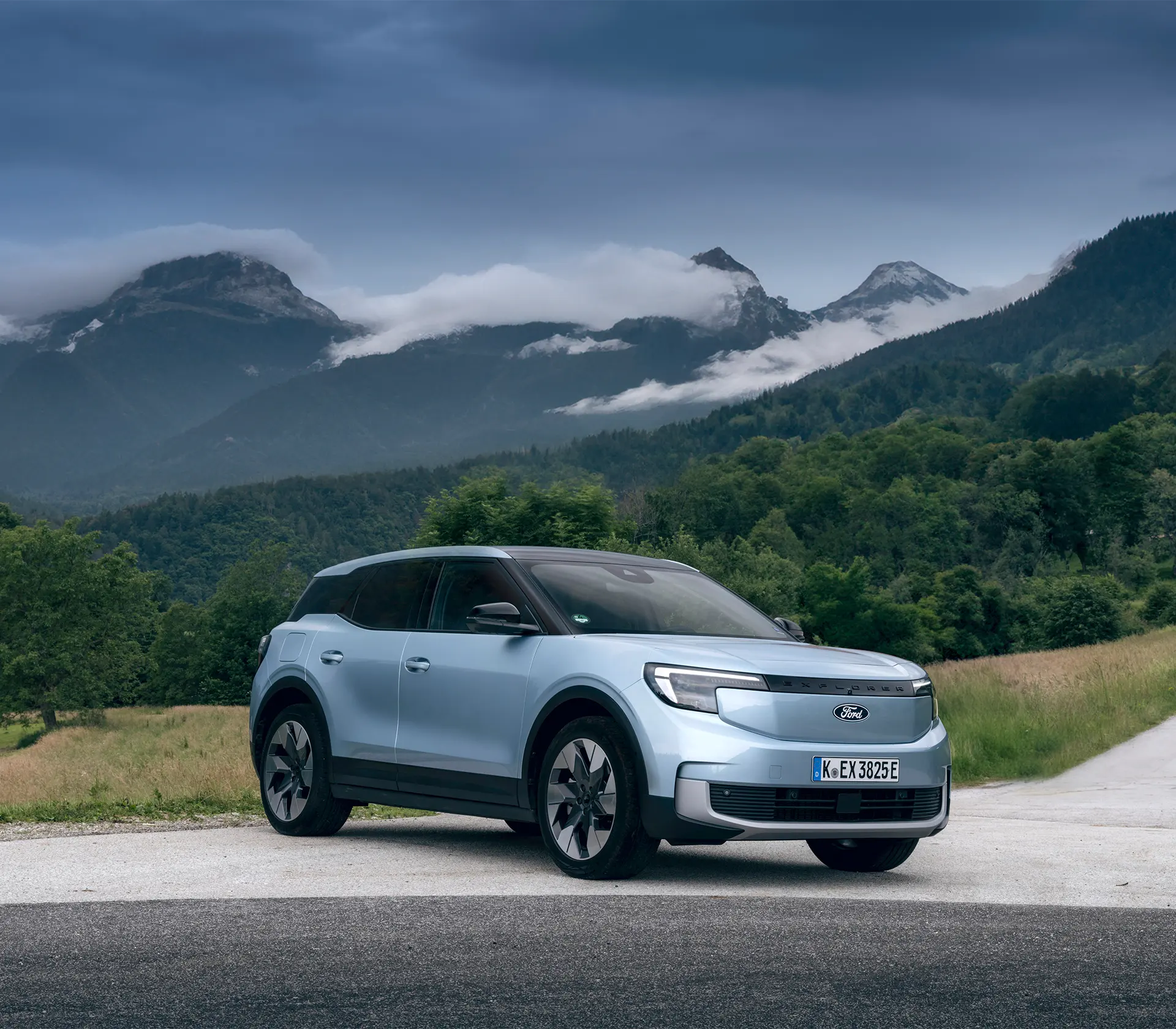 seitliche Ansicht auf einen hellblauen Explorer mit Bergen im Hinterrund