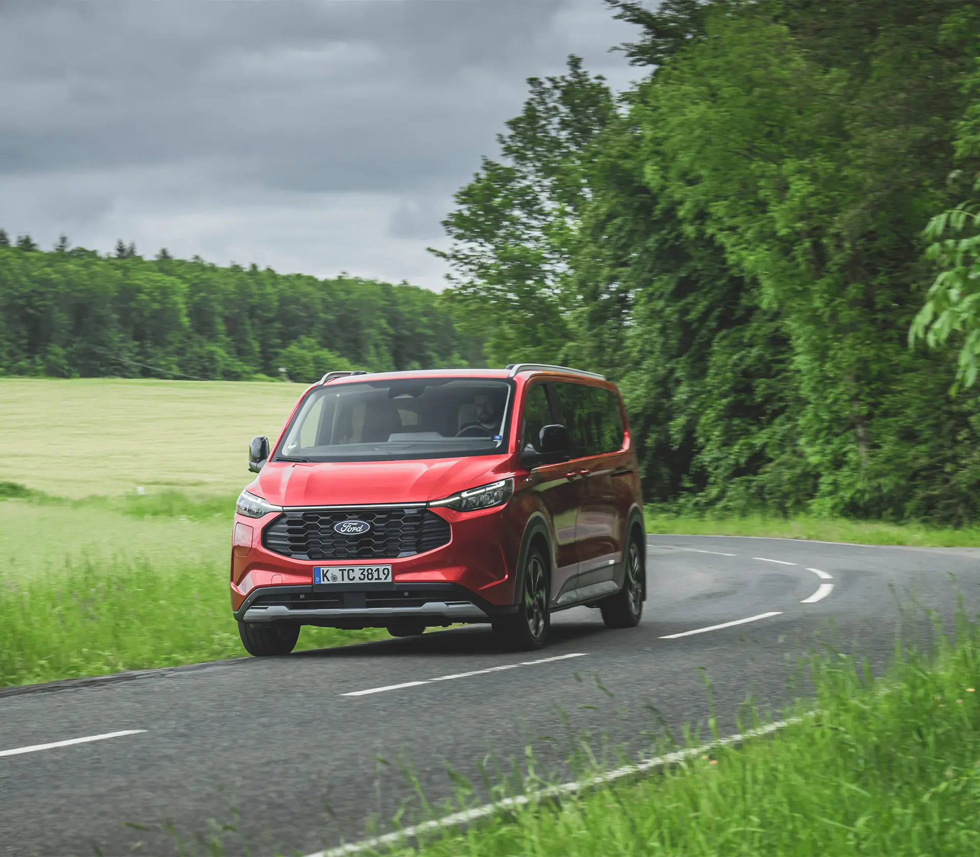 roter Ford Tourneo-Custom fährt auf der Landstraße
