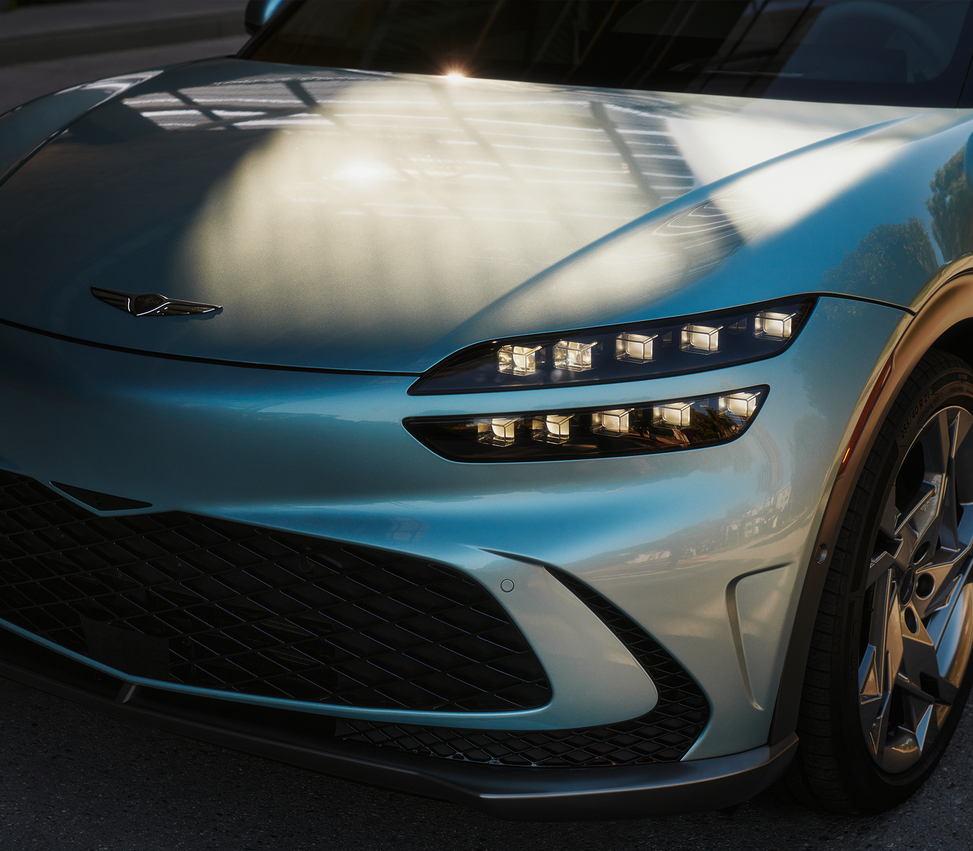 Genesis GV 60 Frontansciht nah, man sieht das Logo und den linken Scheinwerfer