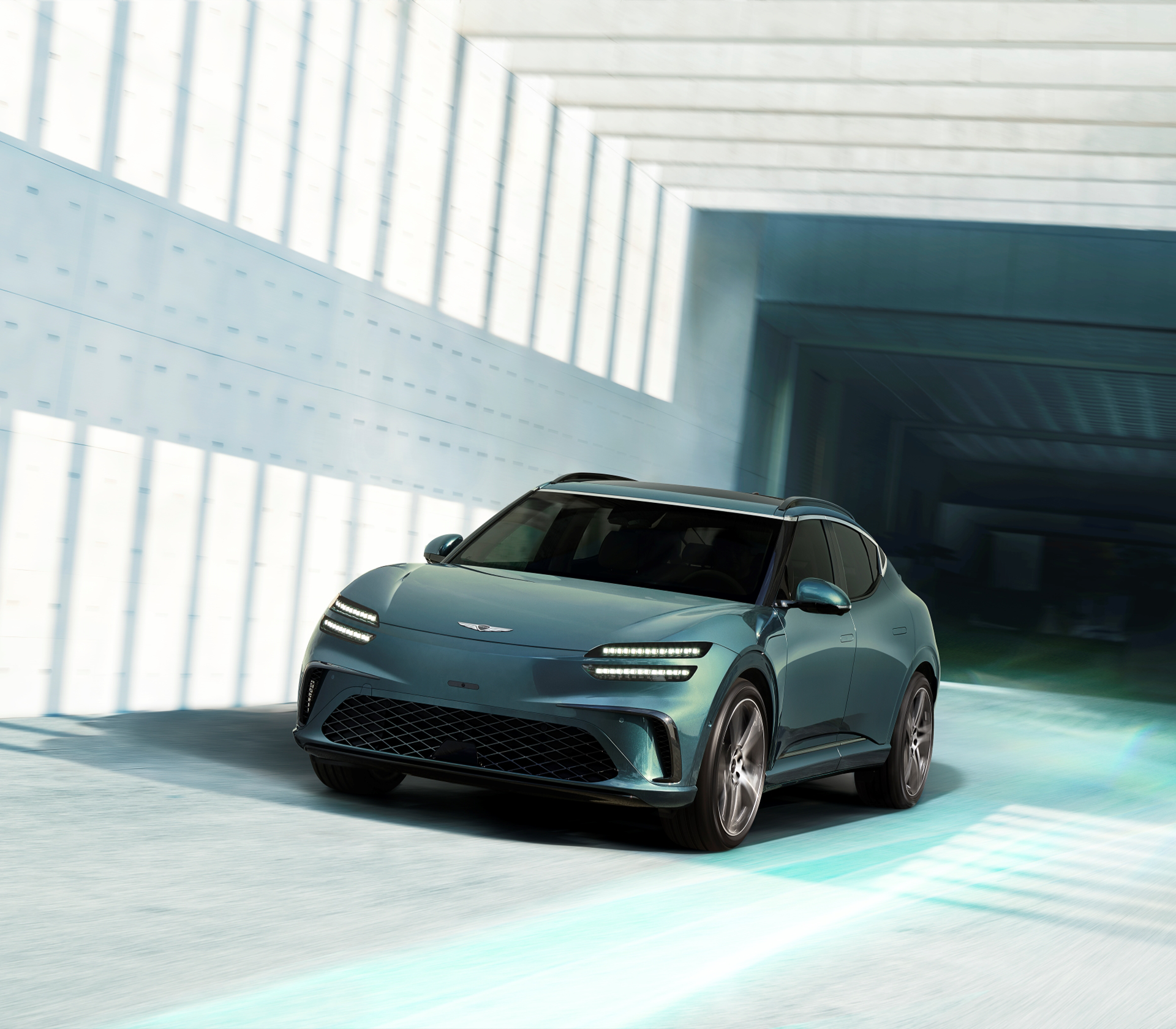 Genesis GV 60 in einer modernen hellen Umgebung von Vorne und der Seite während der Fahrt