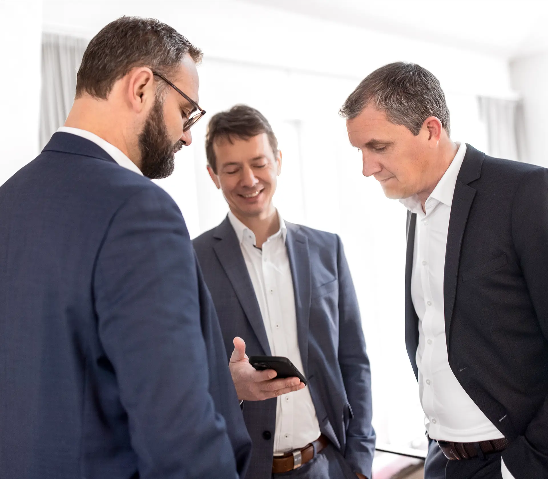 Unser Kunde zeigt stolz auf seinem smartphone seine C02 Ersparnisse durch unsere Flottenoptimieren