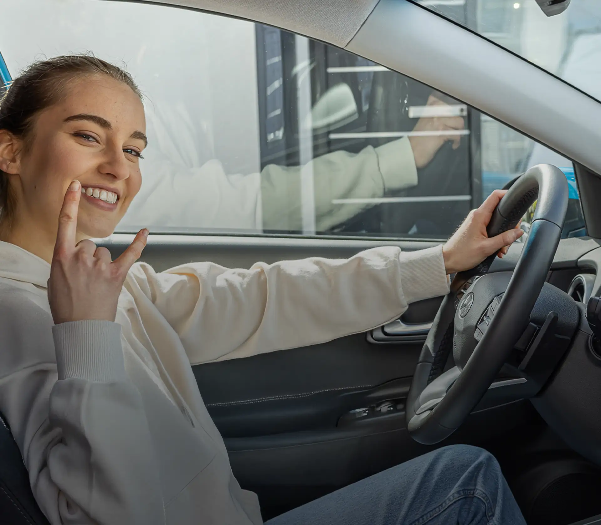 Glückliche Frau sitzt am Steuer Ihres neuen Hyundai