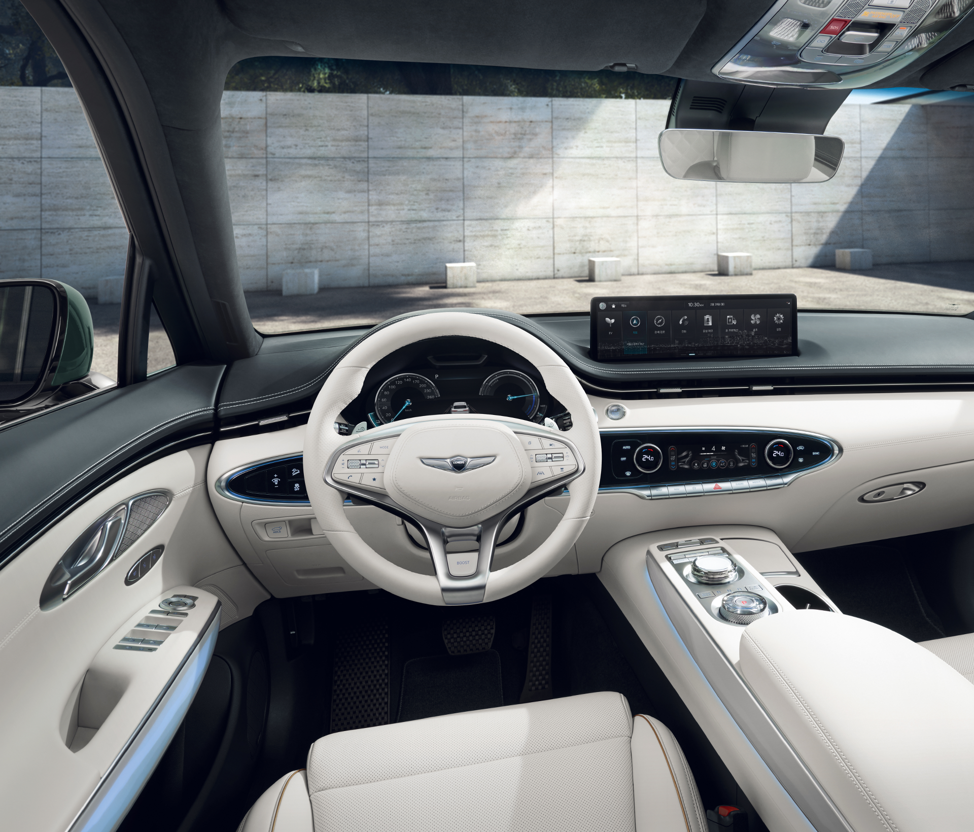 Genesis Electrified GV 70  Innenansciht vom Fahrersitz aus auf das Lenkrad und das weiße Interieur.