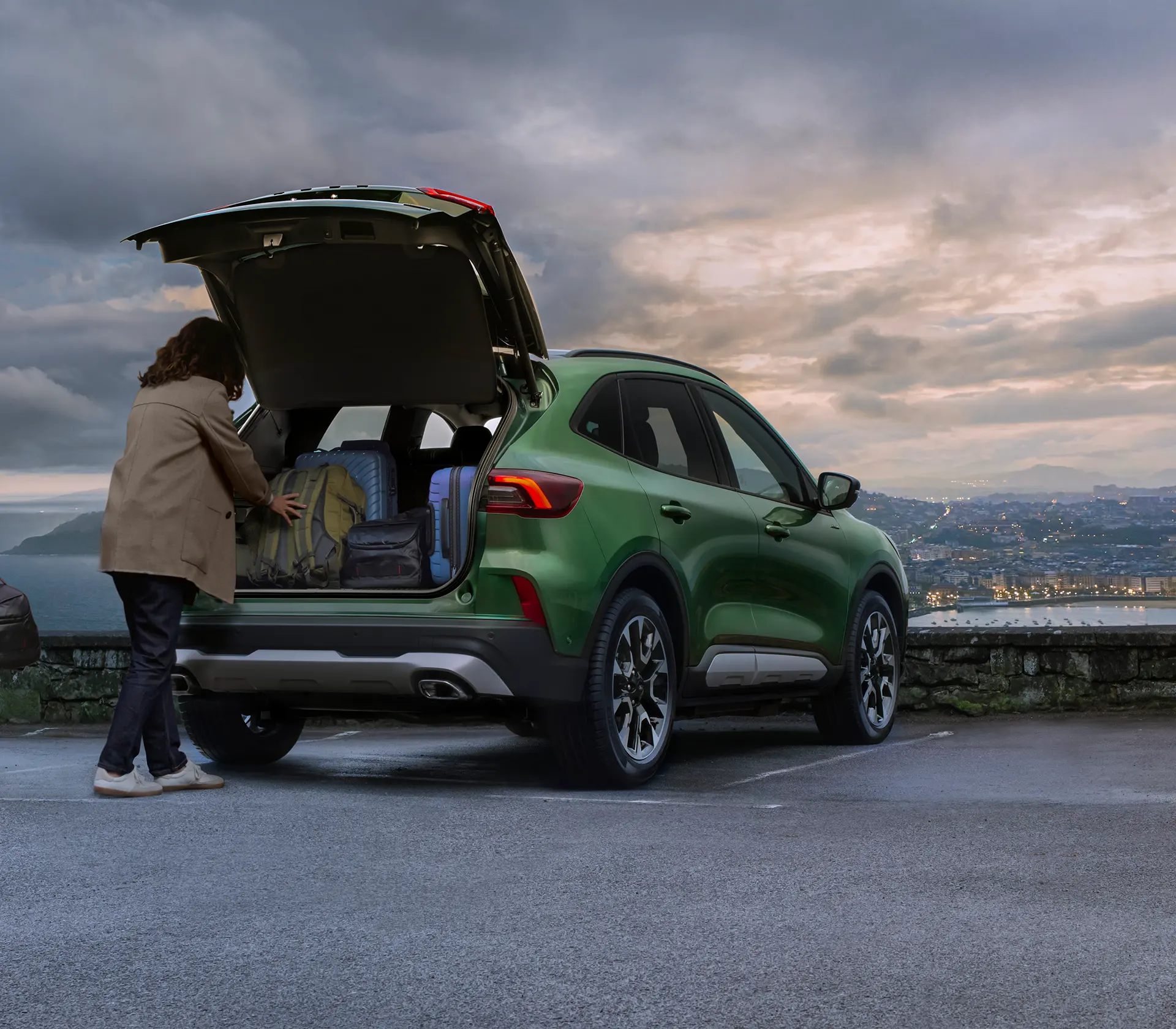 Mann packt Gepäck in den Kofferraum des Kuga