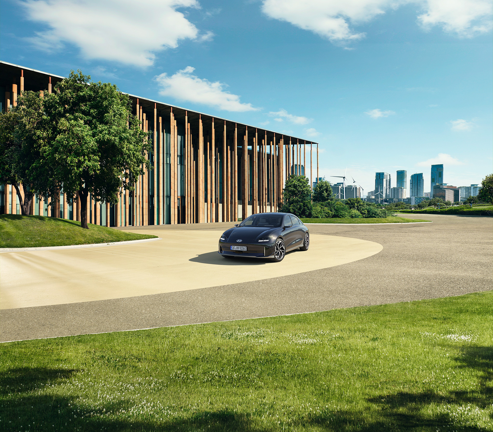 Hyundai IONIC 6 vor einem modernen Gebäude mit Holz und einer Großstdt im Hintergrund