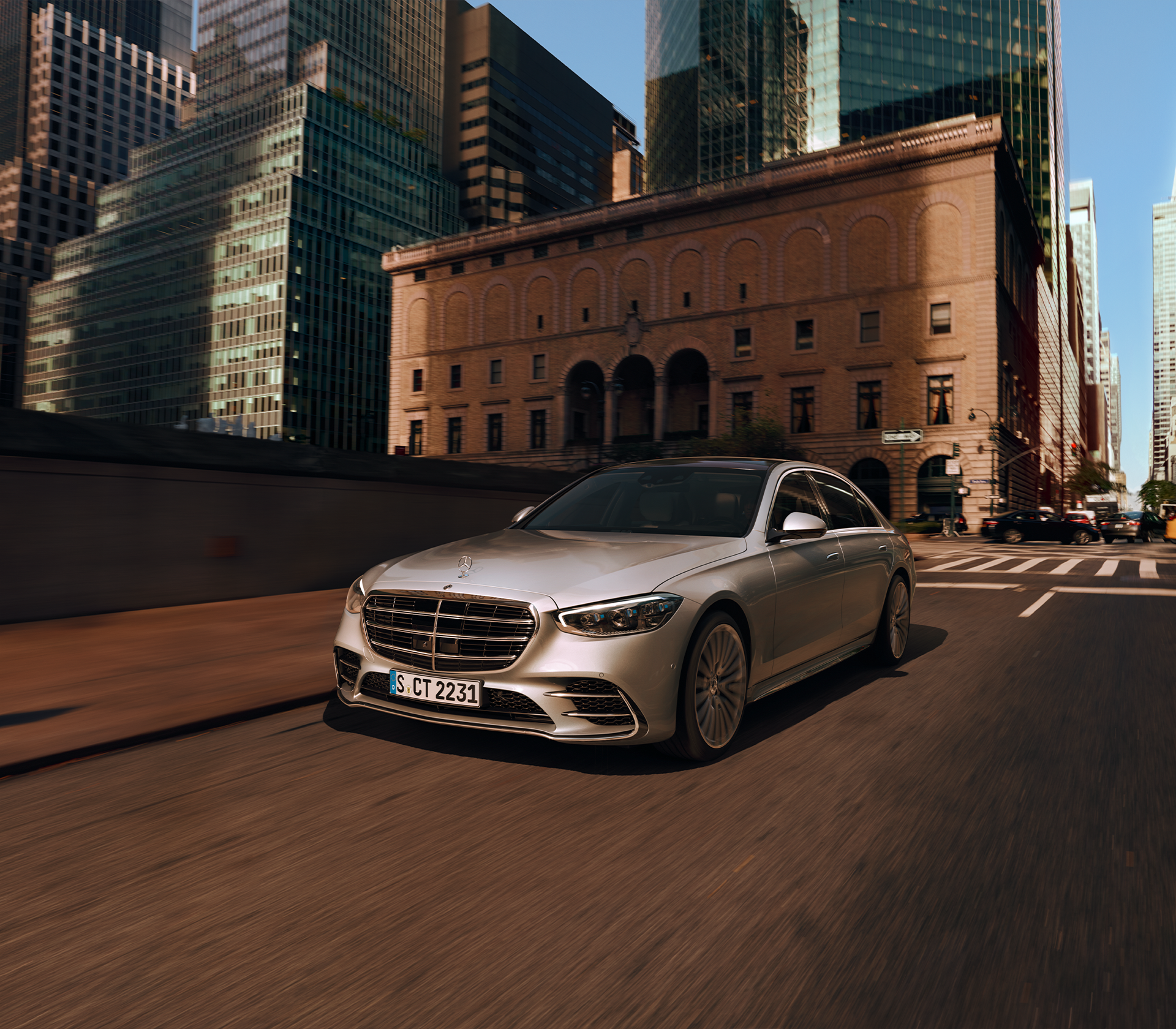 Mercedes-Benz S-Klasse grau während der Fahrt im Hintergrund sind große moderne Häuser 