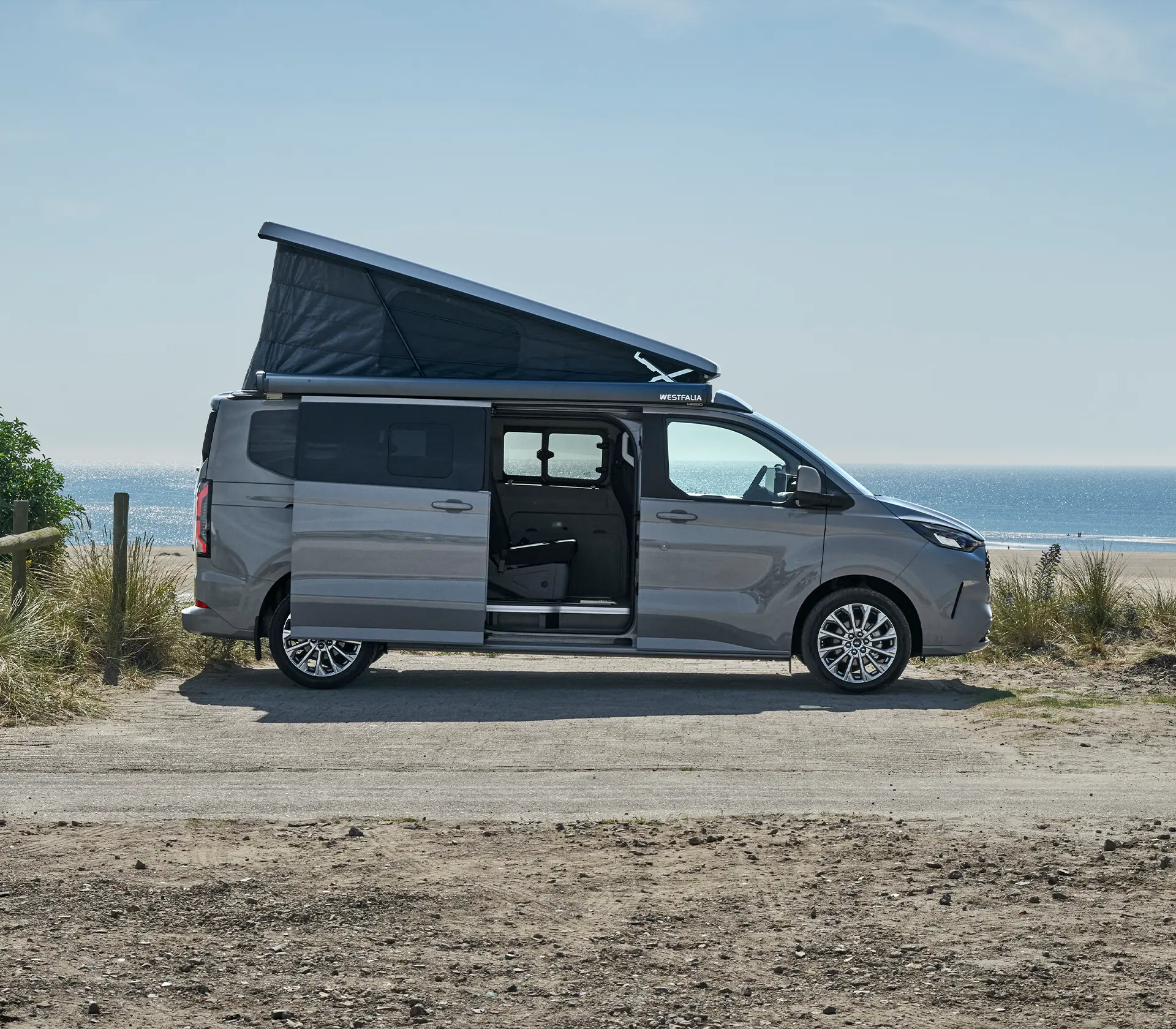 seitliche Ansicht auf grauen Nugget mit offener Seitentür und gehobenen Dach