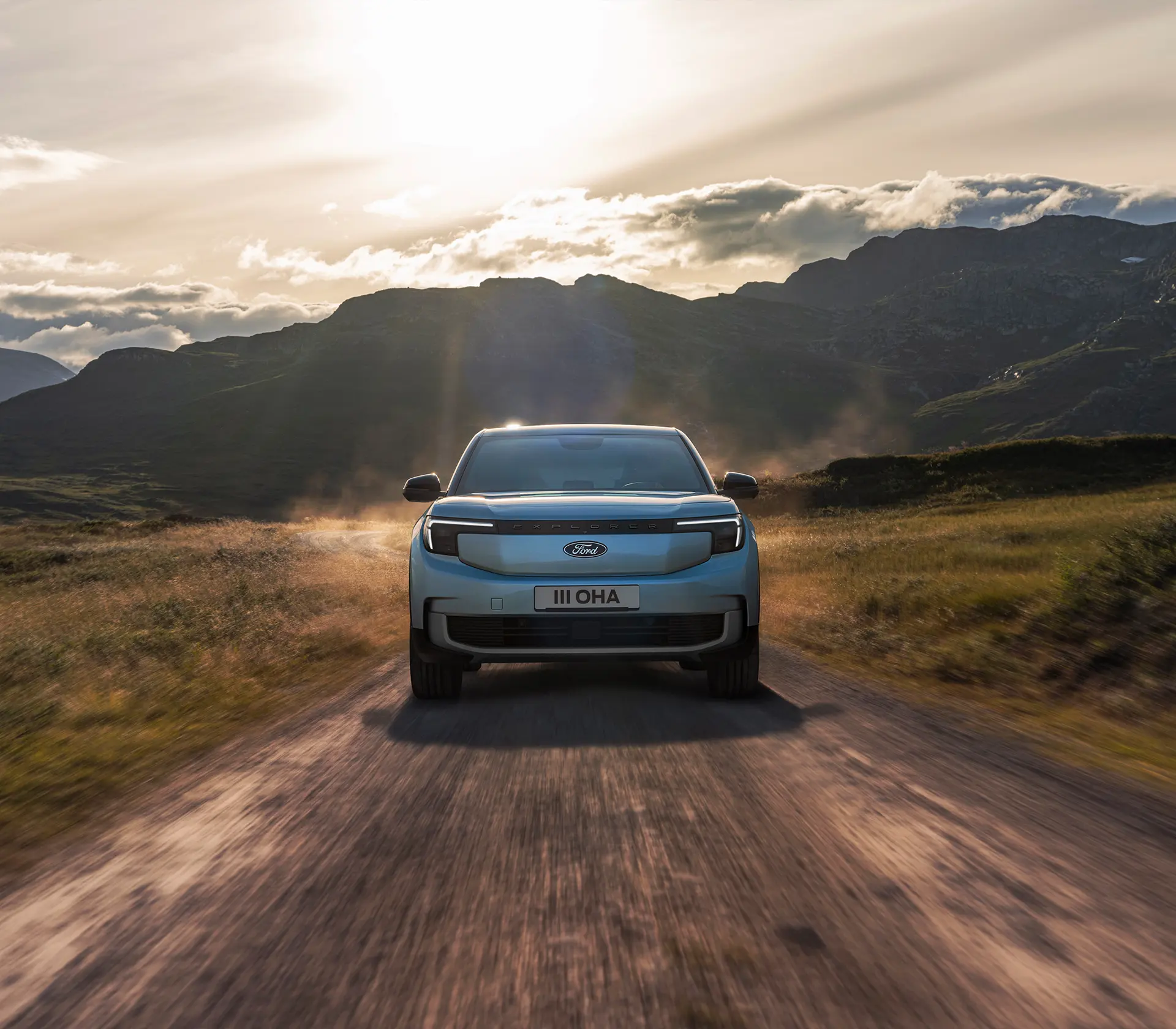 hellblauer Ford Explorer fährt mit Frontansicht auf einer offroad Landstraße