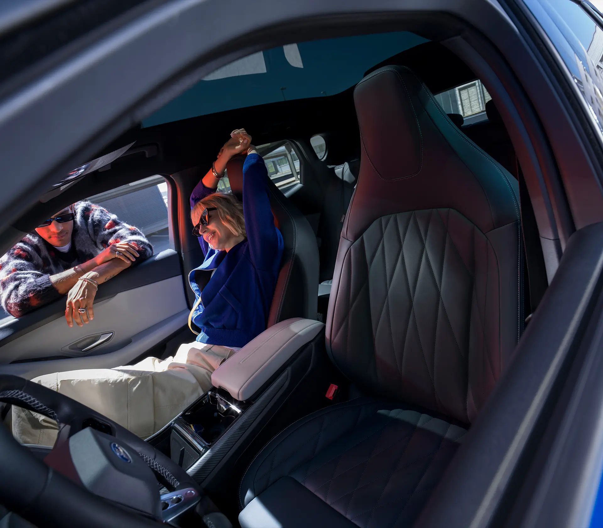 Frau sitzt auf dem Beifahrersitz im Capri, Mann steht am Fenster