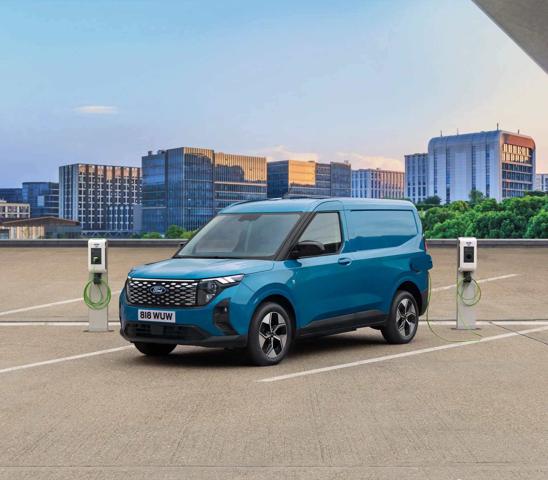 blauer E-Transit Courier auf einem Parkplatz neben einer Ladesäule