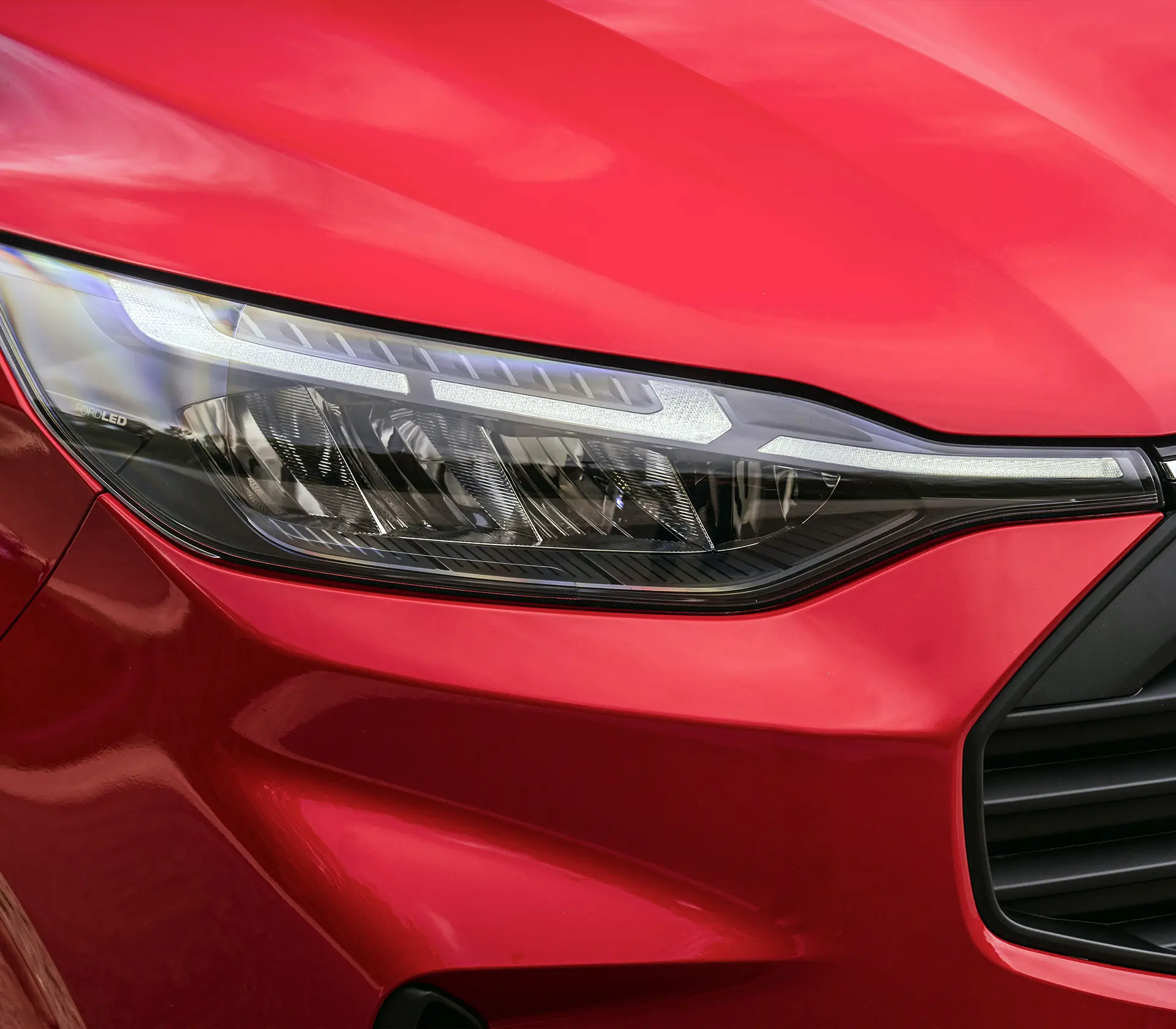 Detailaufnahme des Scheinwerfers vom roten Transit-Custom