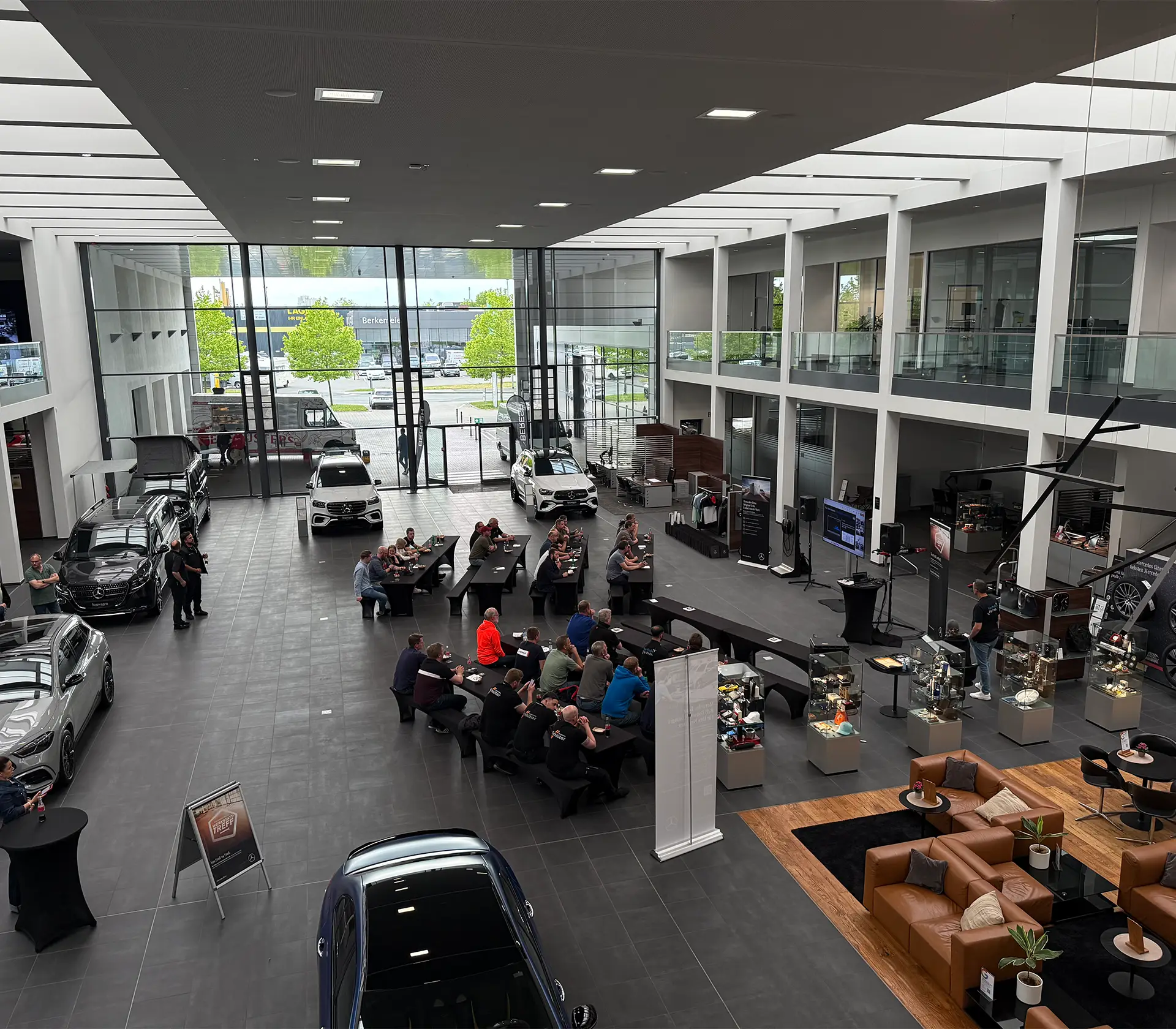 BERESA Münster Showroom ist zu sehen mit vielen Fahzeugen und Tischen und Bänken worauf Menschen sitzen