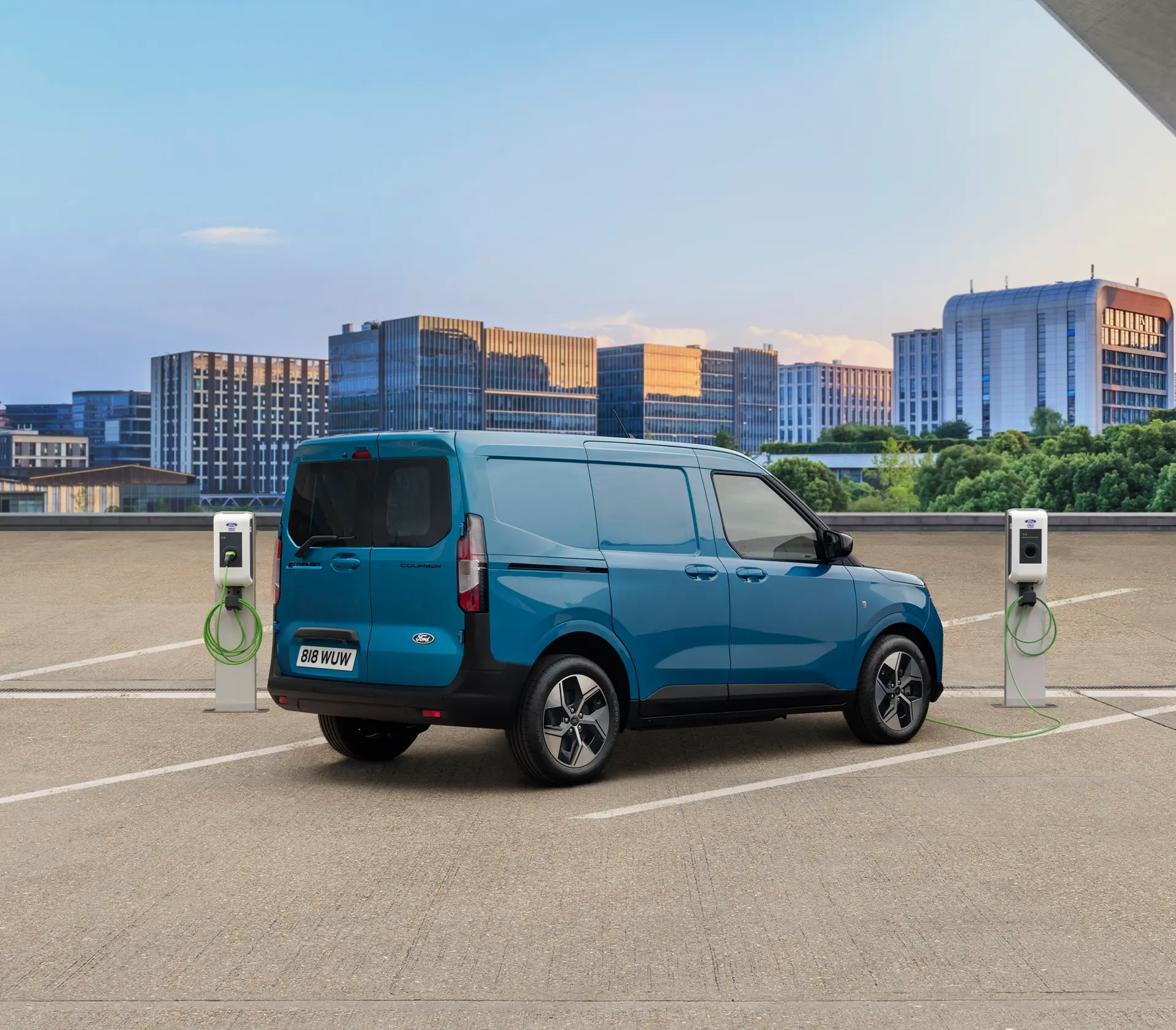 blauer E-Transit Courier auf einem Parkplatz neben einer Ladesäule