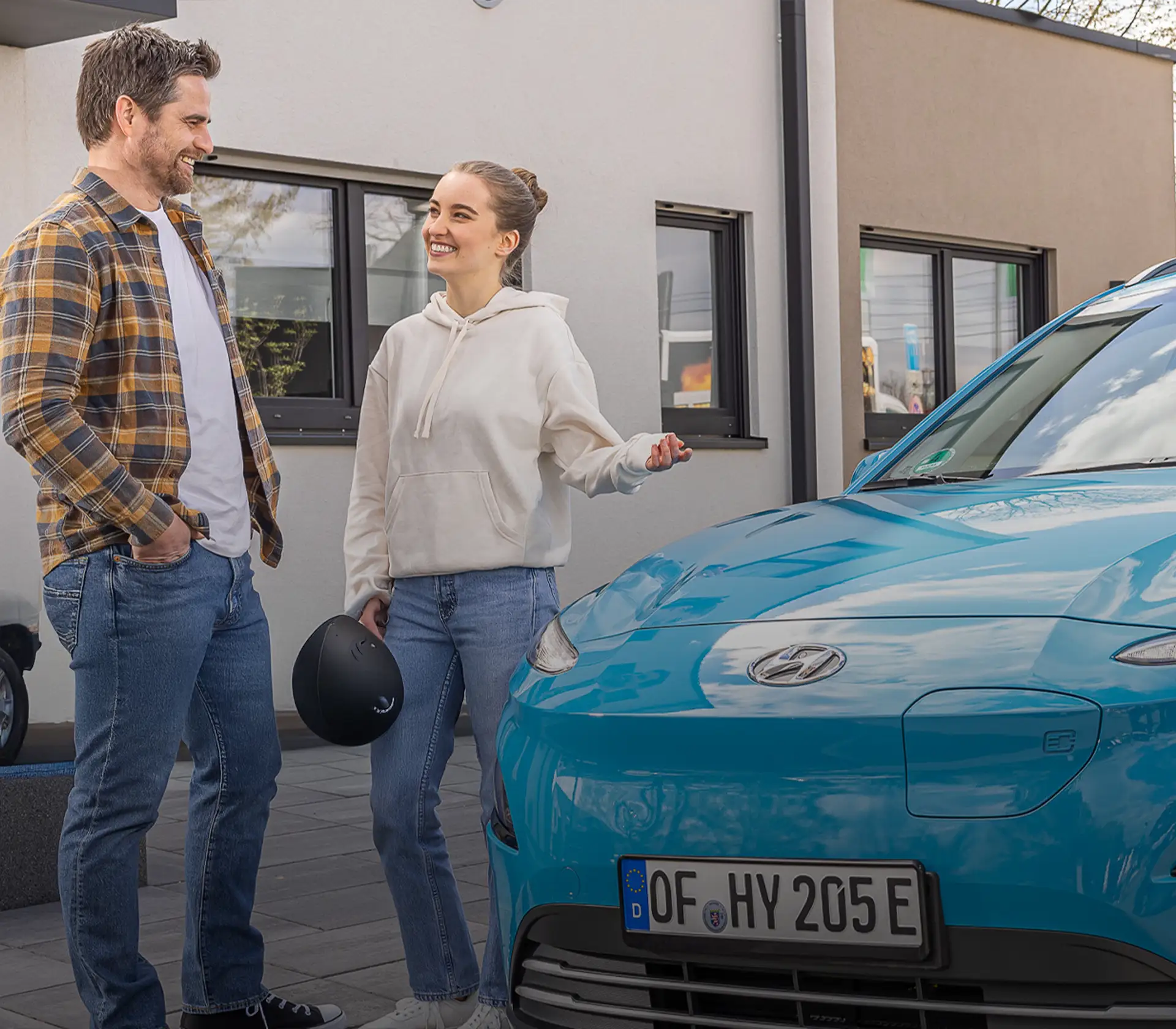 Frau und Mann unterhalten sich vor Kona Elektro