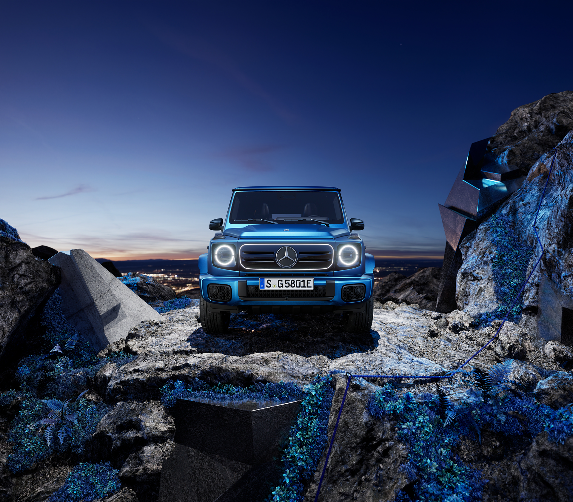 Mercedes-Benz G-Klasse elektrisch in blau steht auf einem Felsen bei Nacht mit einer Stadt unten im Hintergrund