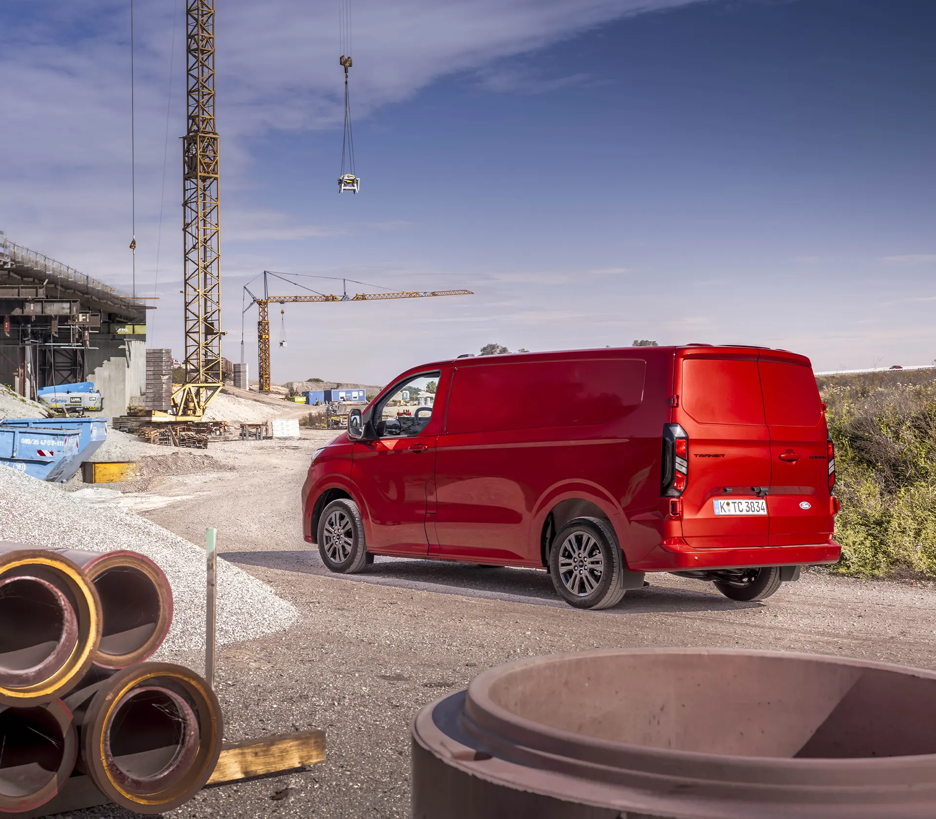 Heckansicht roter Transit-Custom auf einer Baustelle