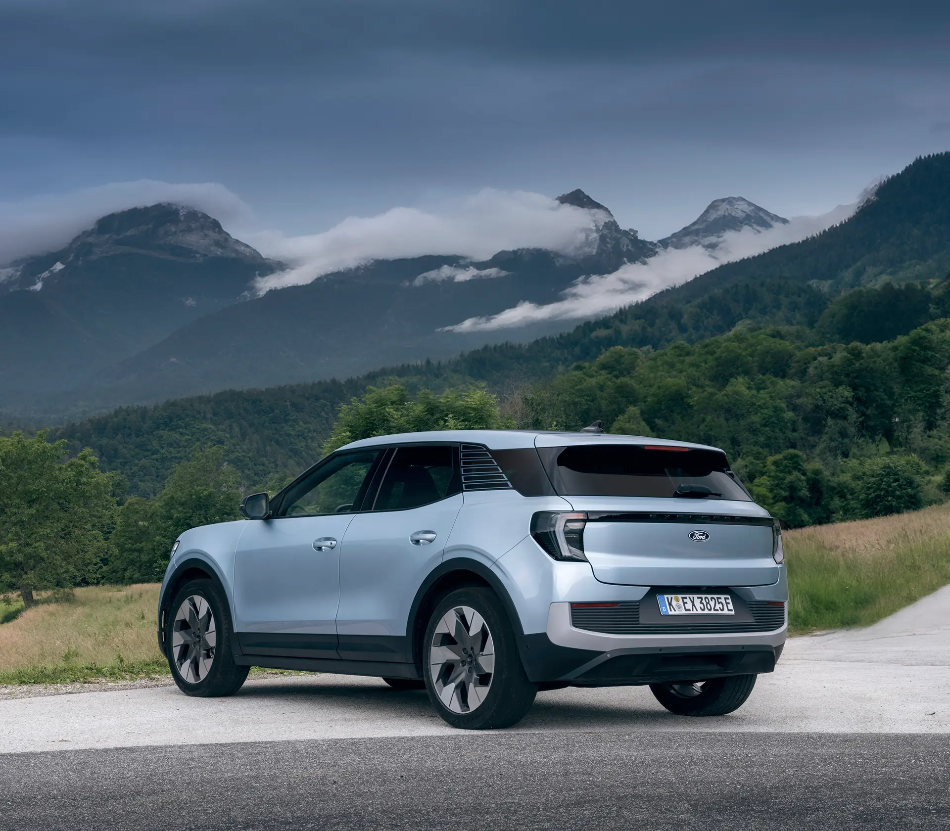 hellblauer Ford Explorer mit Heckansicht mit Bergen im Hintergrund