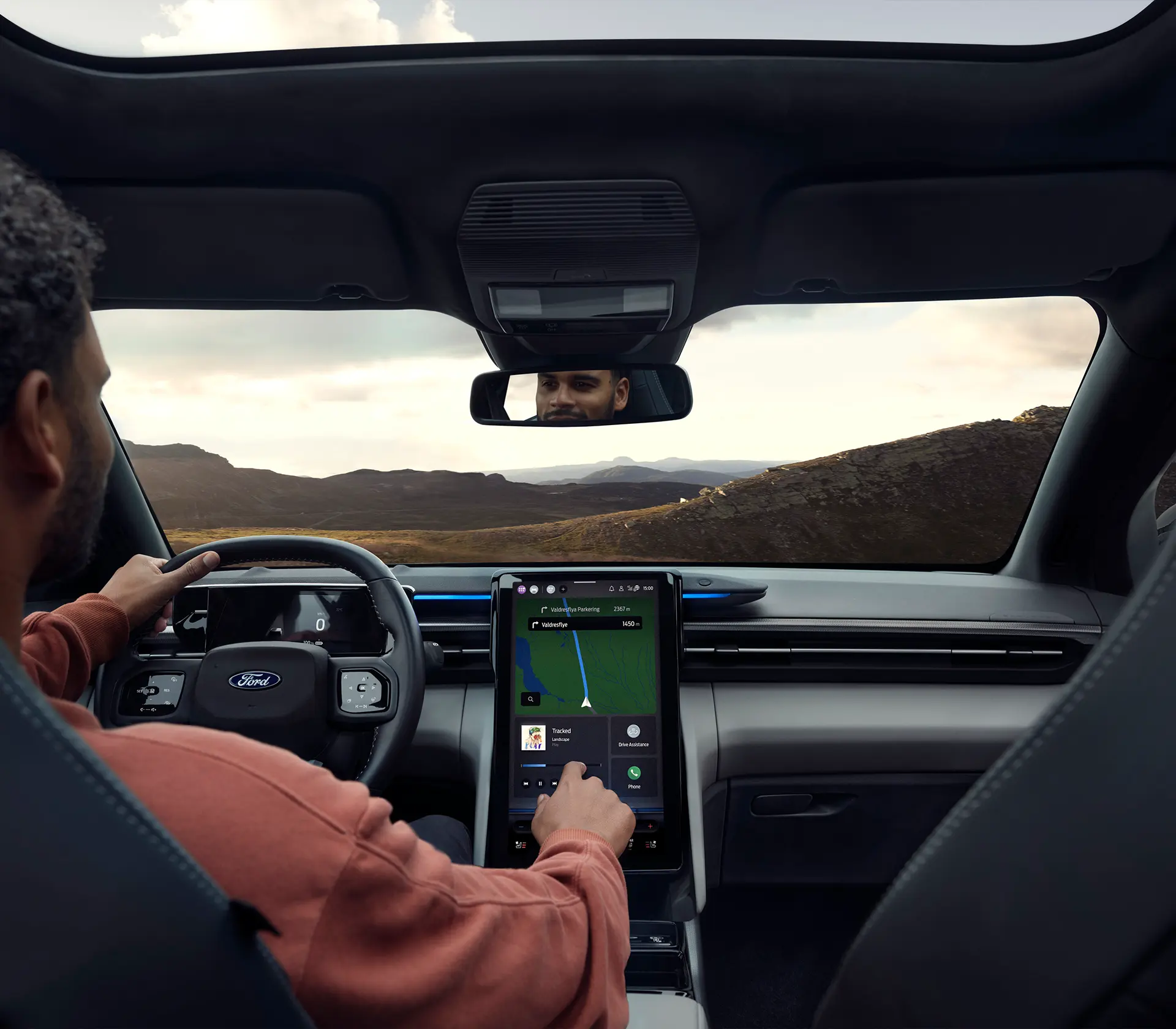 Mann im Fahrersitz bedient das Interieur des Ford Explorer