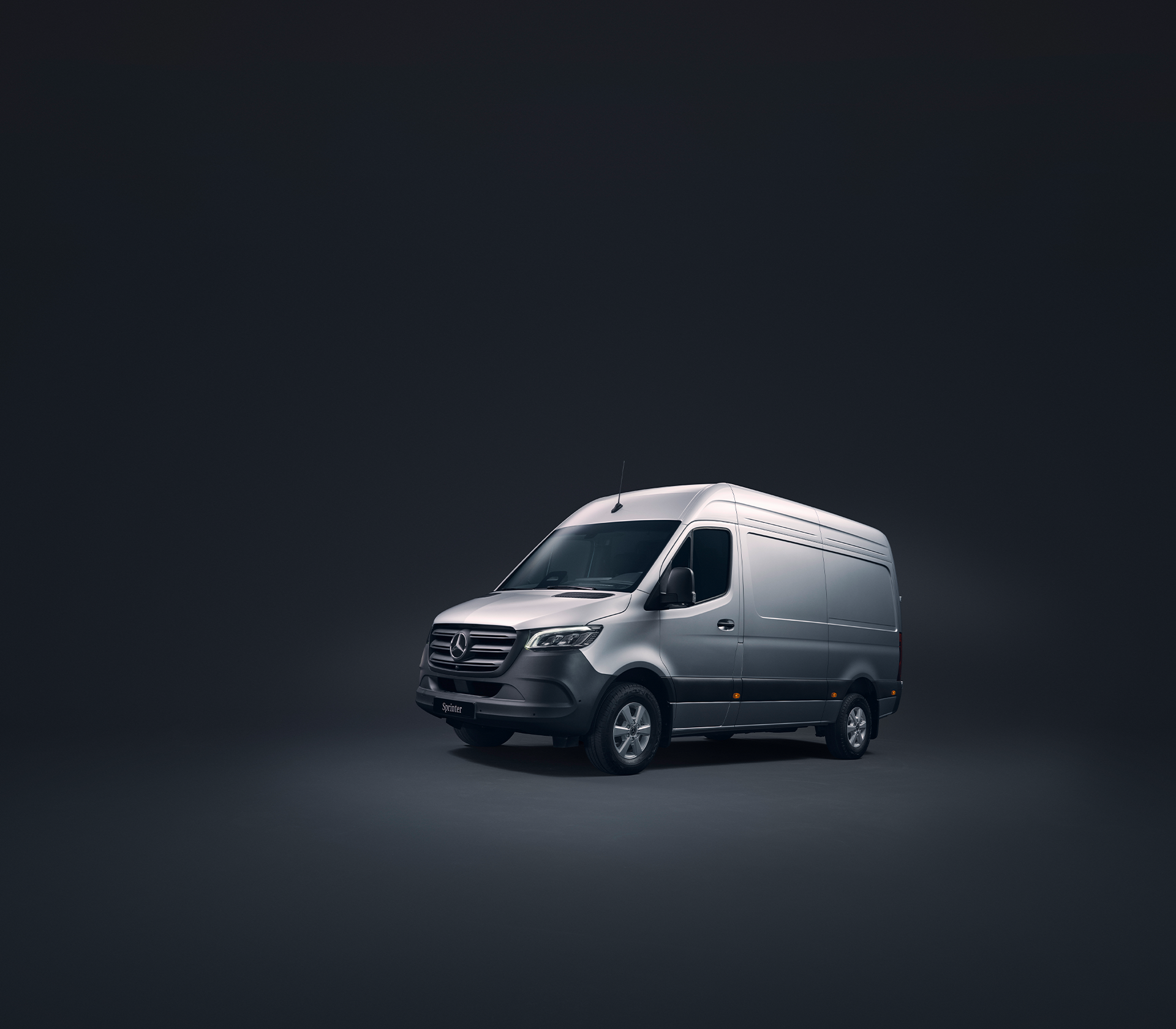 Mercedes-Benz Sprinter in grau schräg von der Seite in einer schwarzen Studioumgebung