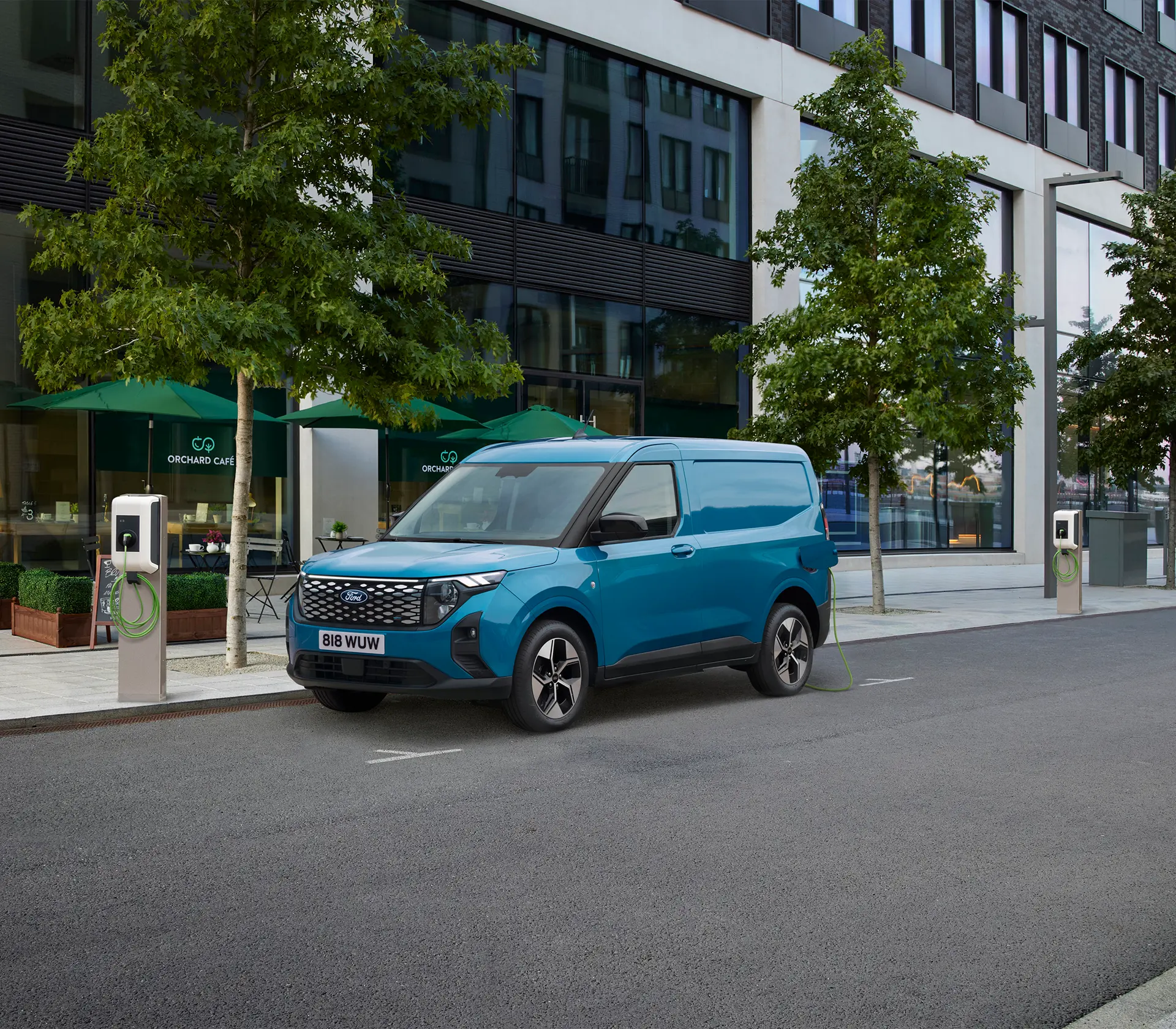 blauer E-Transit Courier auf der Straße neben einer Ladesäule