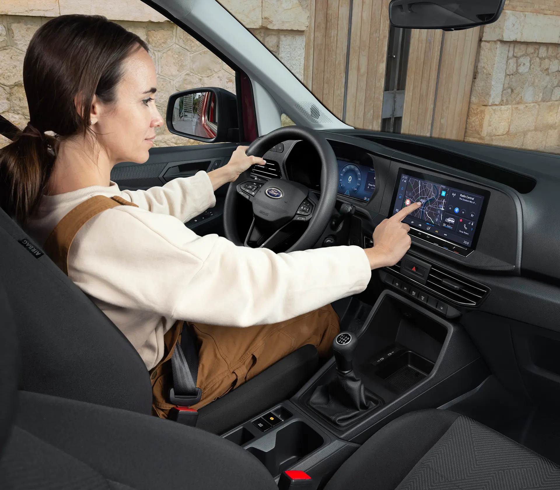 Frau in Arbeitskleidung bedient das Interieur des Transit-Connect