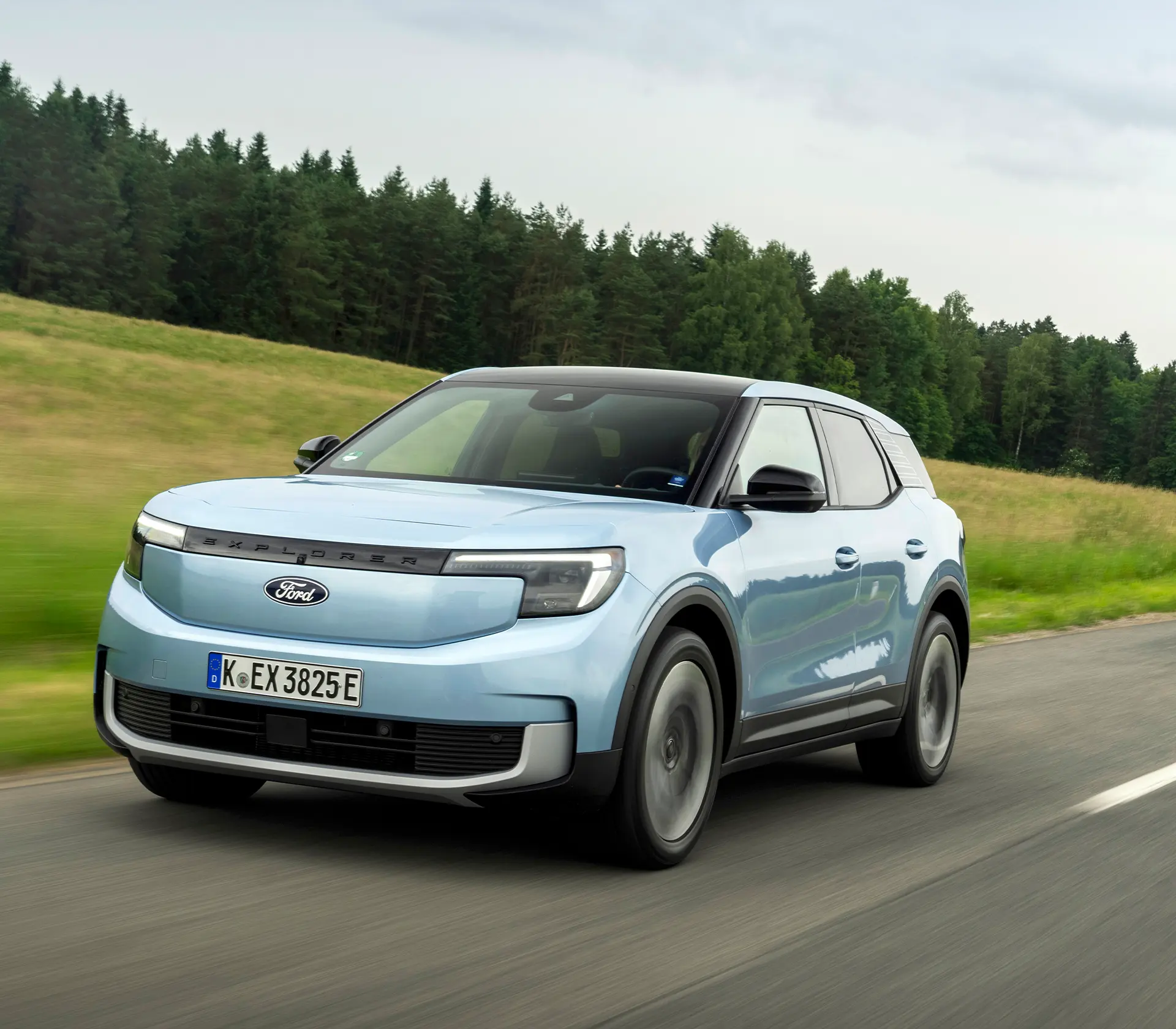 hellblauer Ford Explorer fährt mit Frontansicht auf einer Landstraße