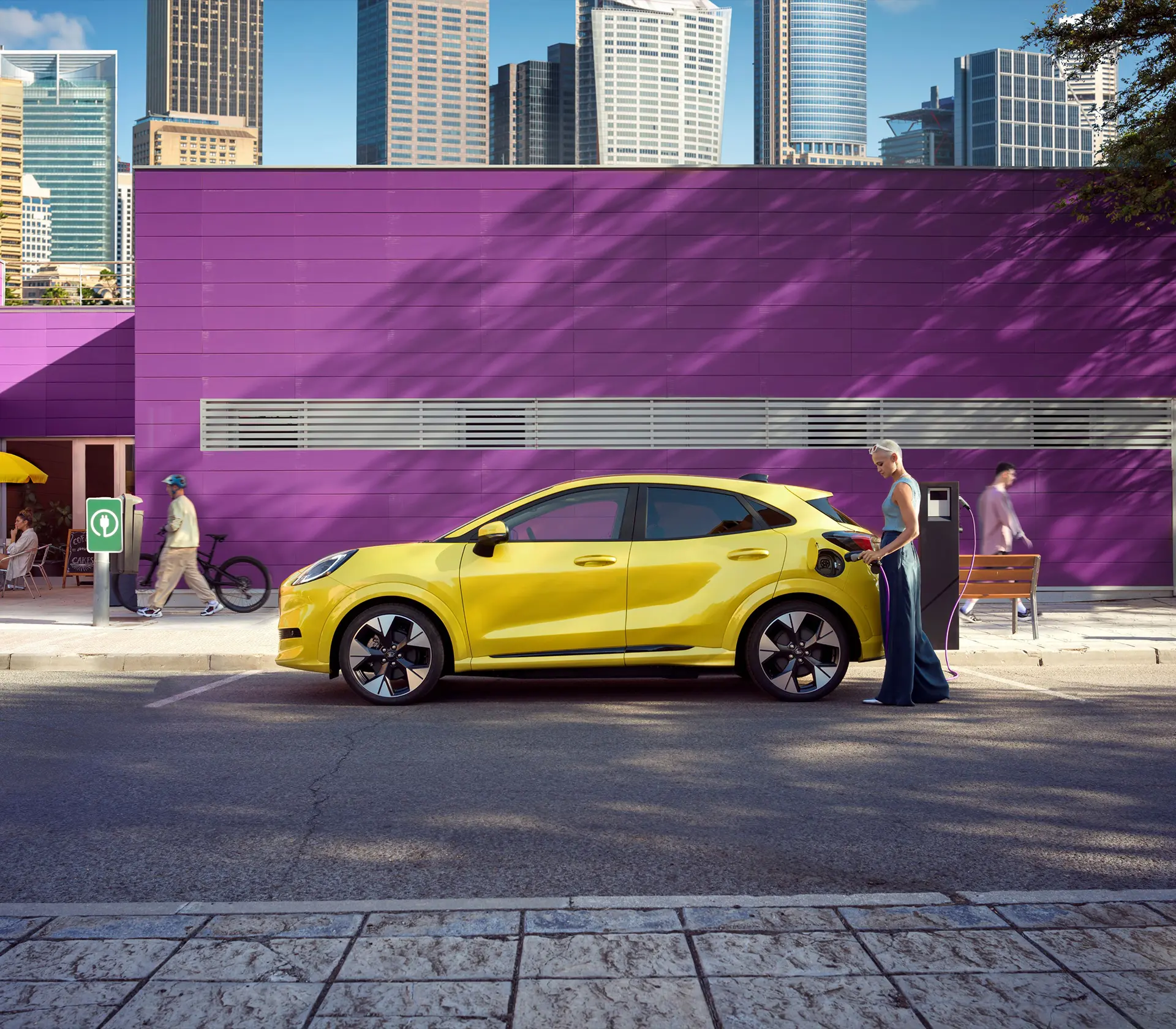 Frau läd den gelben Puma Gen-e an der Ladesäule