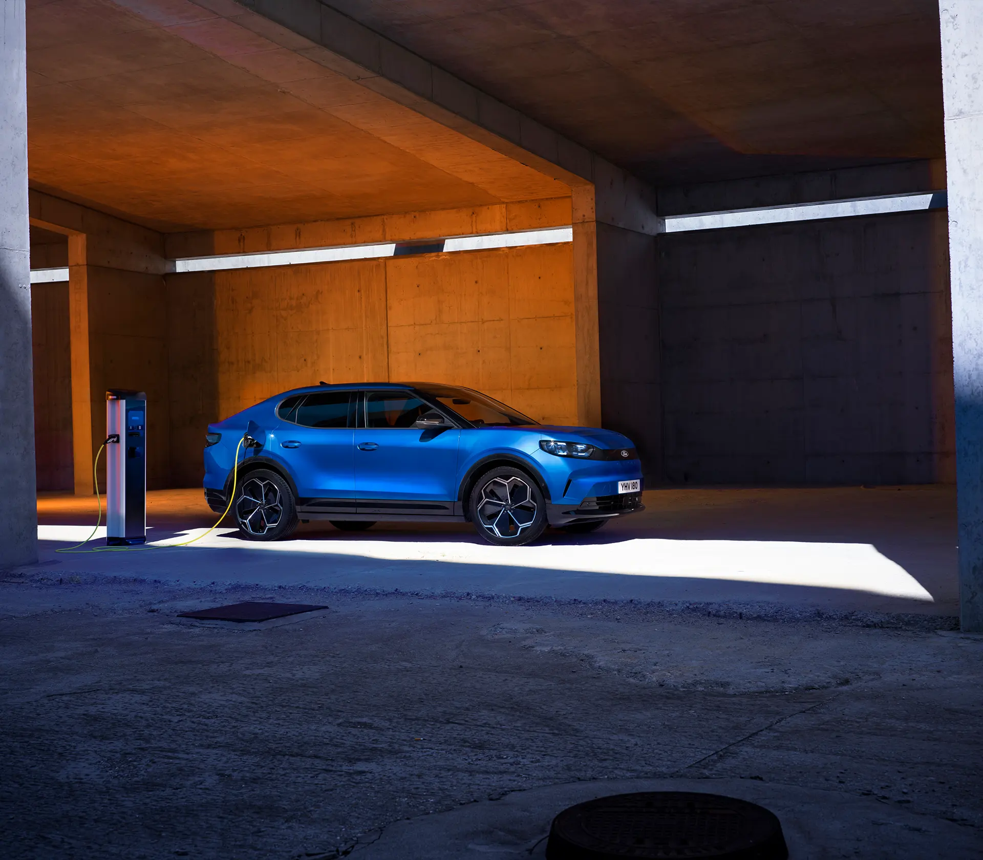 Blauer Capri läd an einer Ladesäule