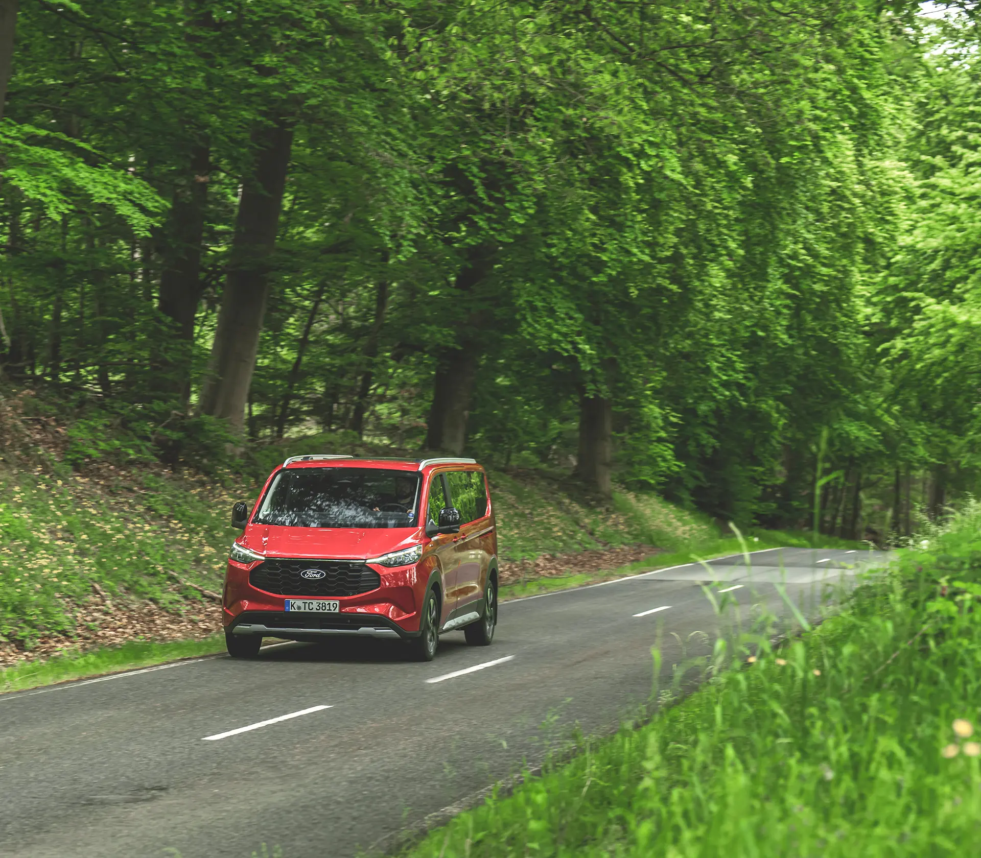 roter Ford Tourneo-Custom fährt auf der Landstraße