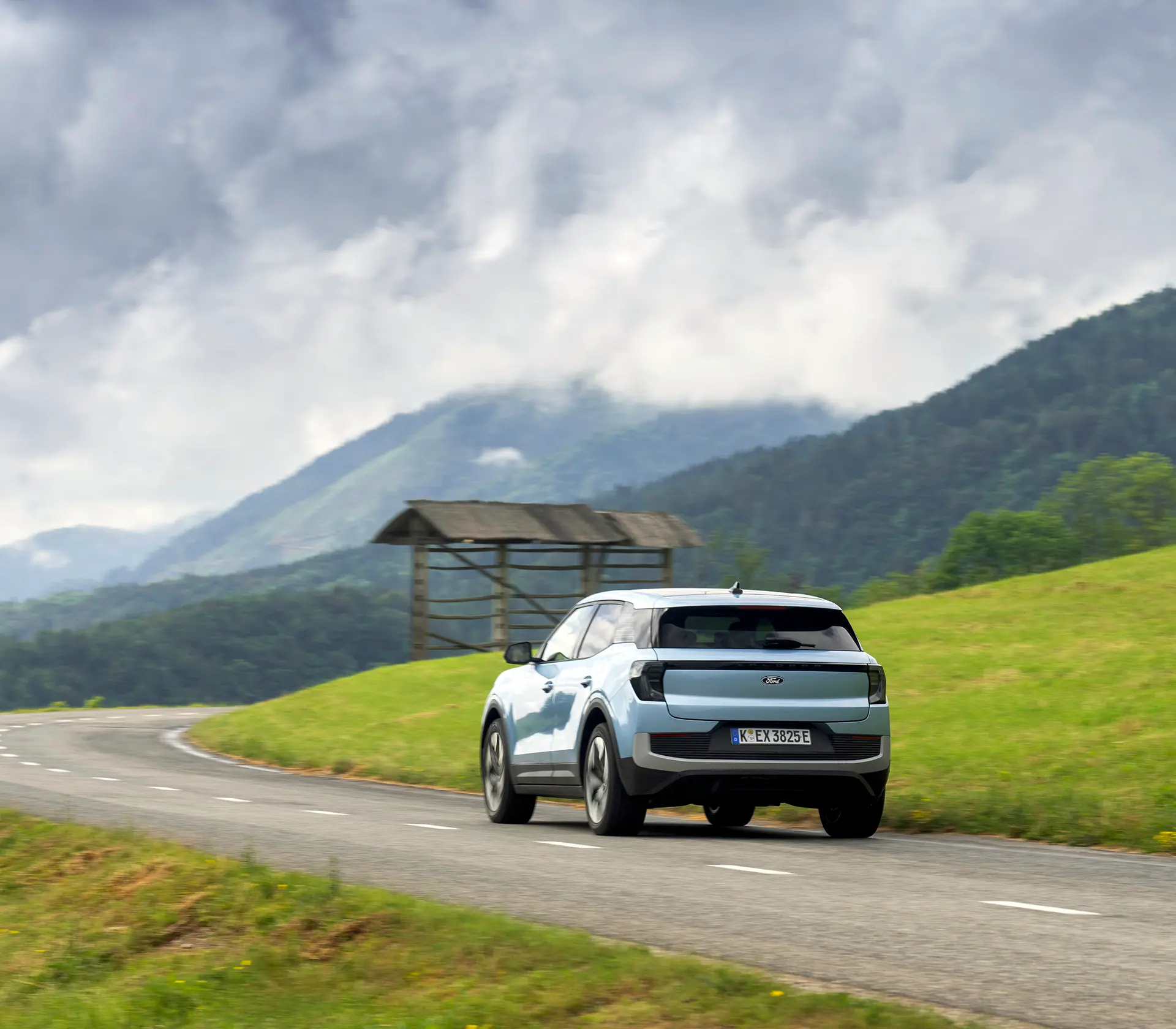 hellblauer Ford Explorer fährt mit Heckansicht auf einer Landstraße