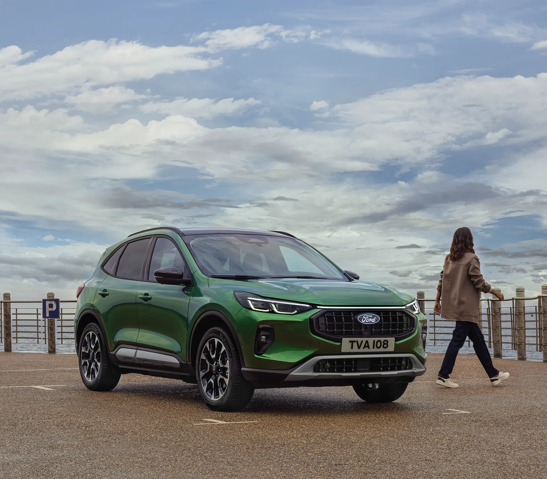 grüner Kuga auf dem Steg geparkt, Frau verlässt das Auto