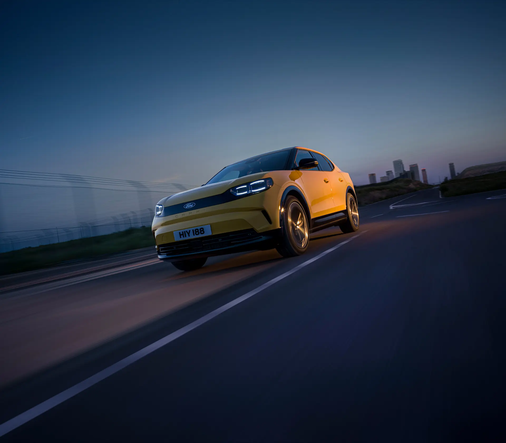 gelber Capri fährt bei Dämmerung auf der Straße