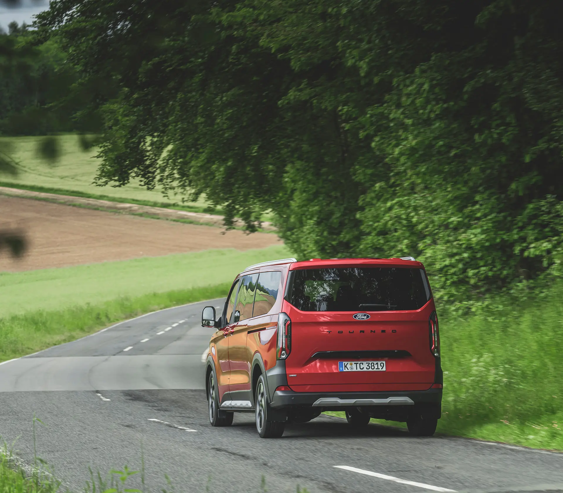 roter Ford Tourneo-Custom fährt auf der Landstraße