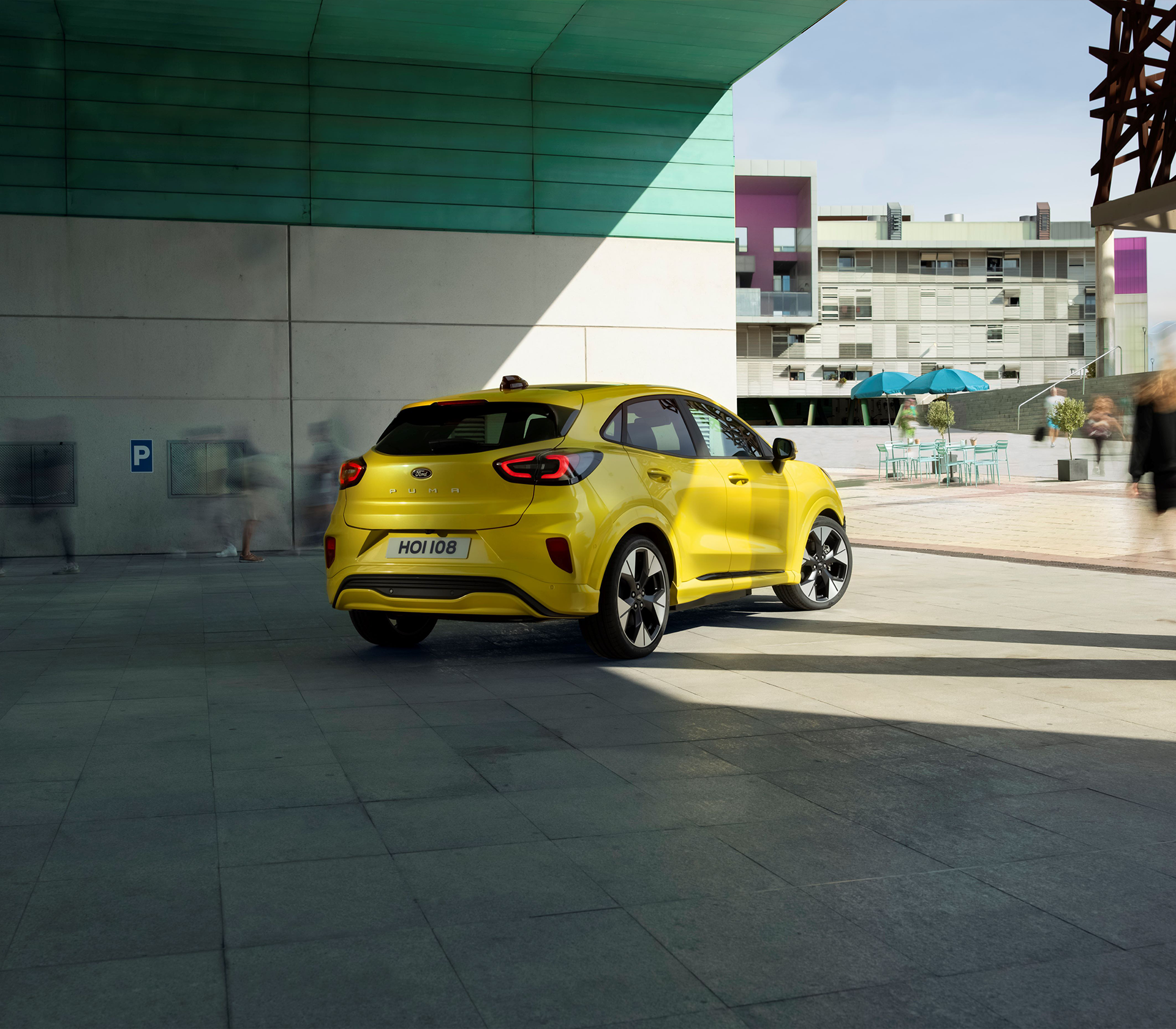 Ford Puma E in gelb Heckansicht und von der Seite geparkt