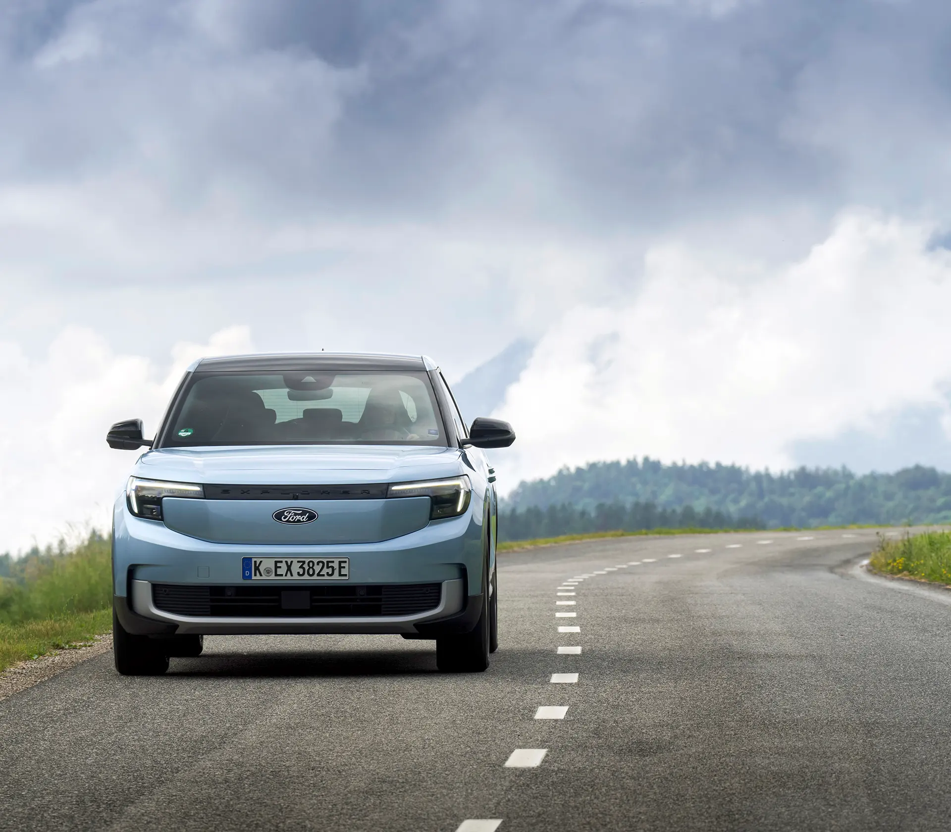 hellblauer Ford Explorer fährt mit Frontansicht auf einer Landstraße