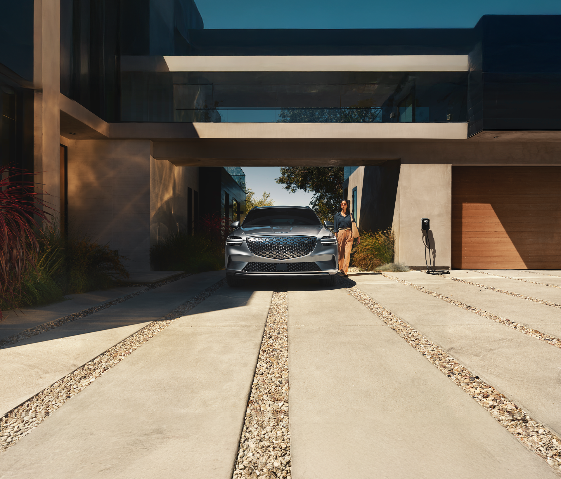 Genesis Electrified GV 70 Frontansicht zwischen uns unter einer Brücke von einem Gebäude