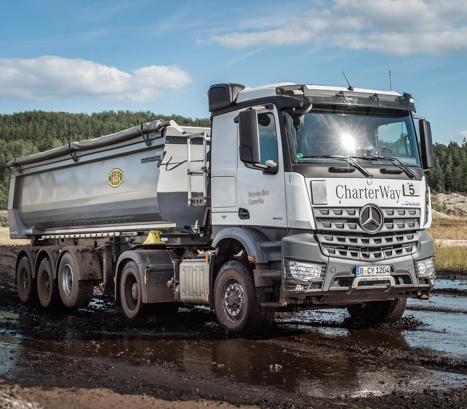 Mercedes Arocs Kipplader fährt durch Schlamm