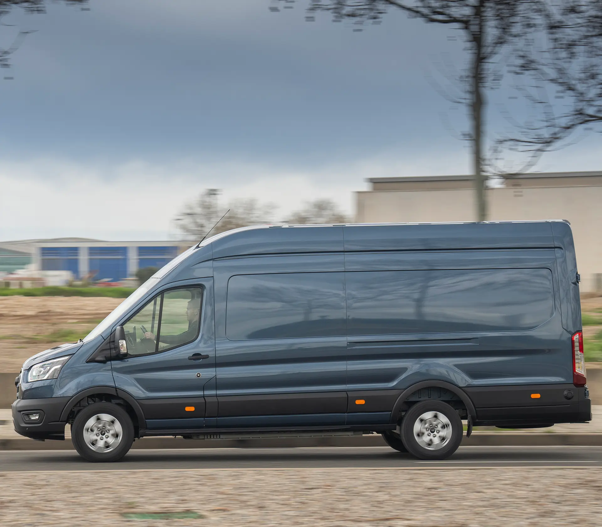 Seitenansicht auf einen fahrenden blauen E-Transit