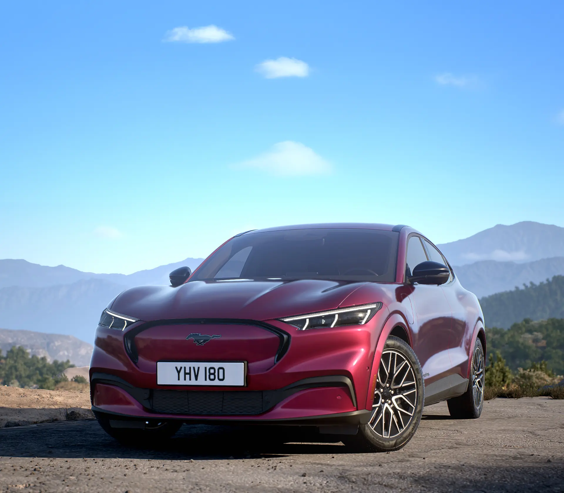 vordere Ansicht auf den roten Mustang Mach-E mit bergen im Hintergrund