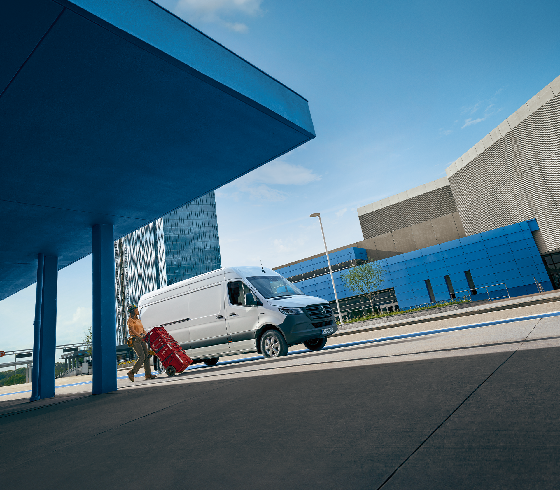 Mercedes-Benz e-Sprinter in weiß und ein Mensch steht davor und rollt Kästen weg