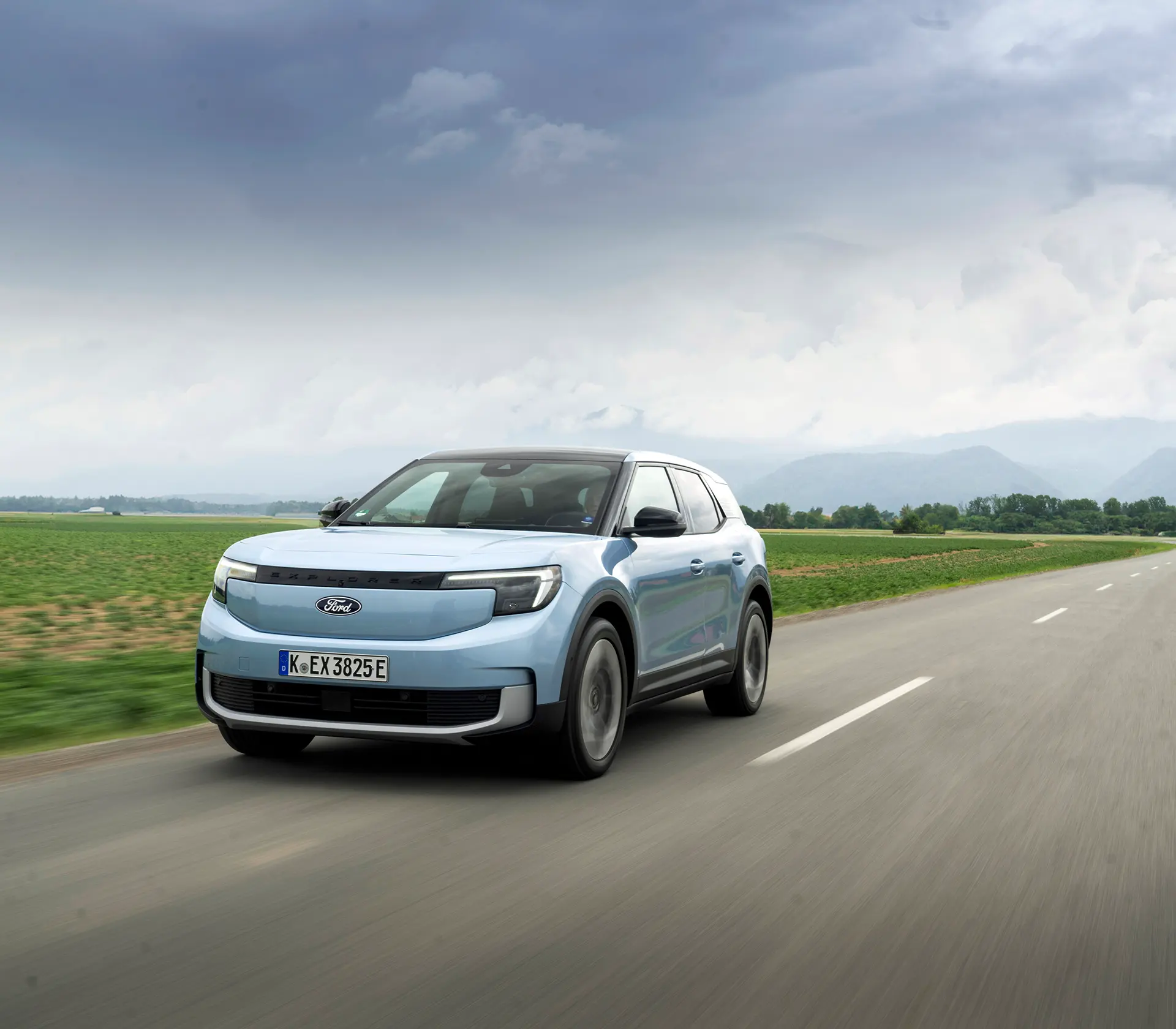 hellblauer Ford Explorer fährt mit Frontansicht auf einer Landstraße