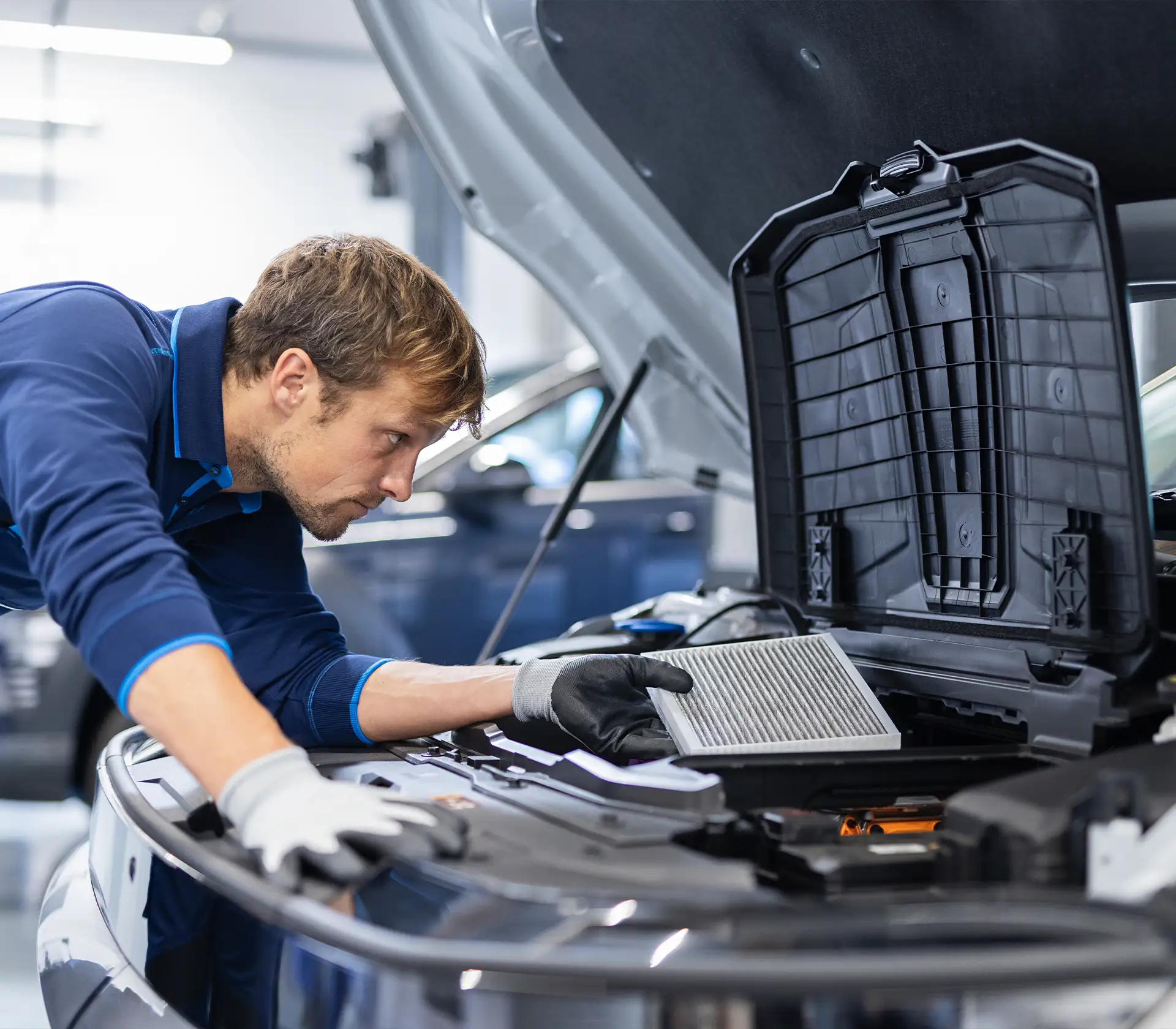 Mechaniker tauscht den Aktivkohlefilter aus