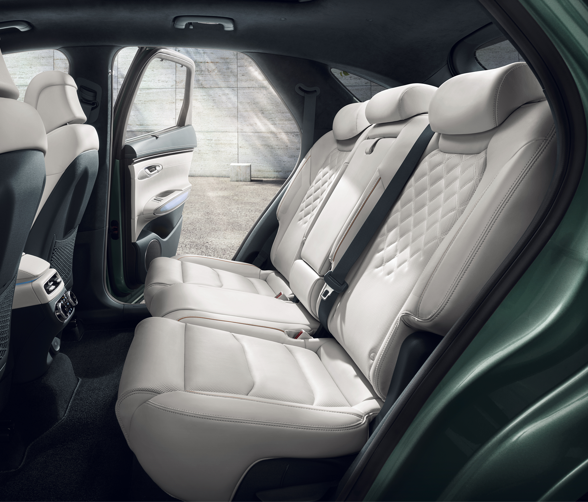 Genesis Electrified GV 70 Innenansciht durch die Tür auf die hinteren weißen Ledersitze. Die Tür gegenüber ist ebenfalls offen.