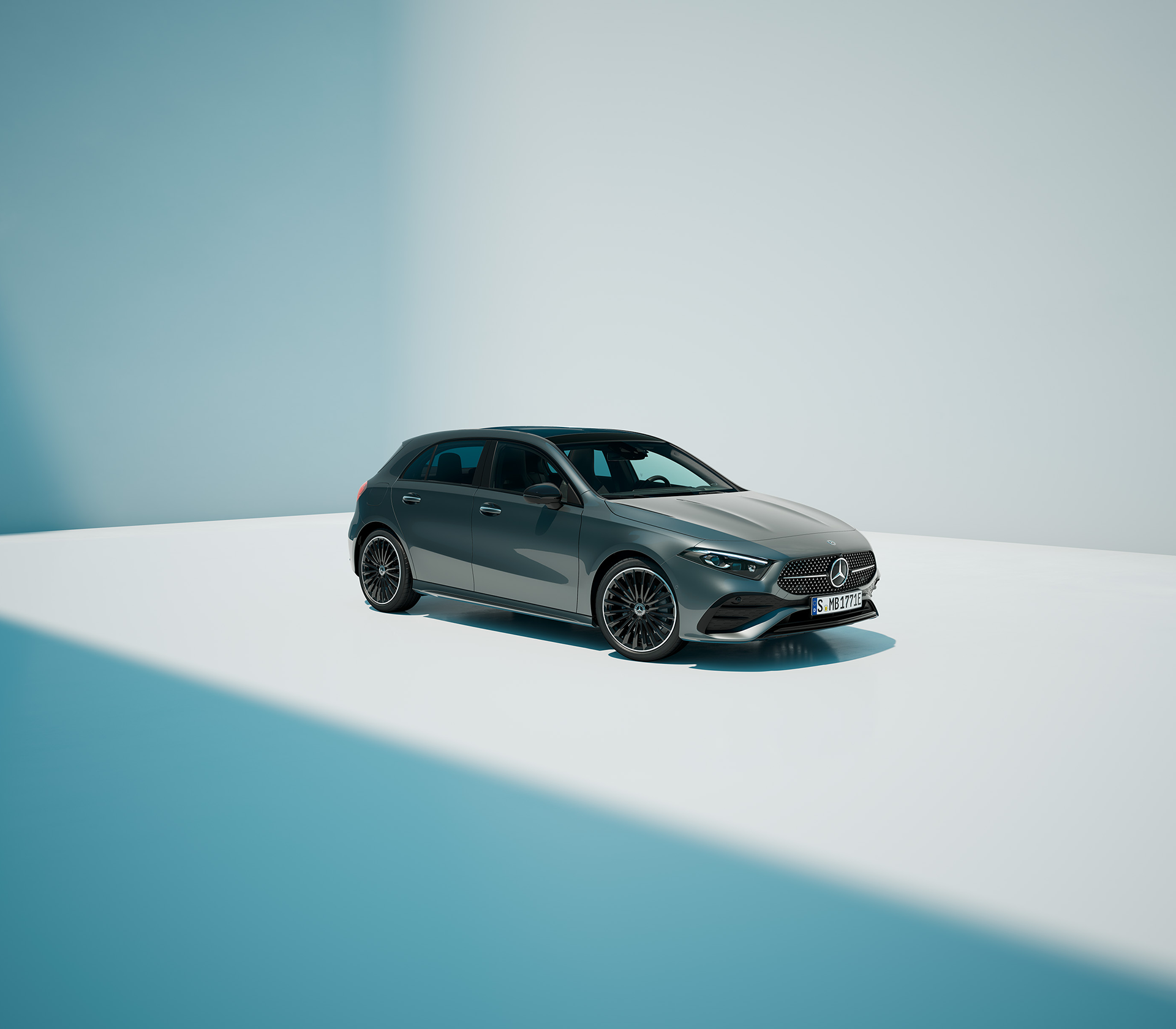Mercedes-Benz A-Klasse in elegantem Grau, inszeniert in einer minimalistischen Studio-Umgebung mit Licht- und Schattenspiel.