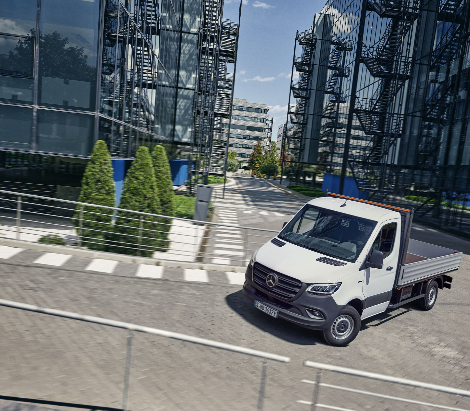 Mercedes-Benz e-Sprinter biegt in eine Strape ab mit Gebäuden im hintergrund