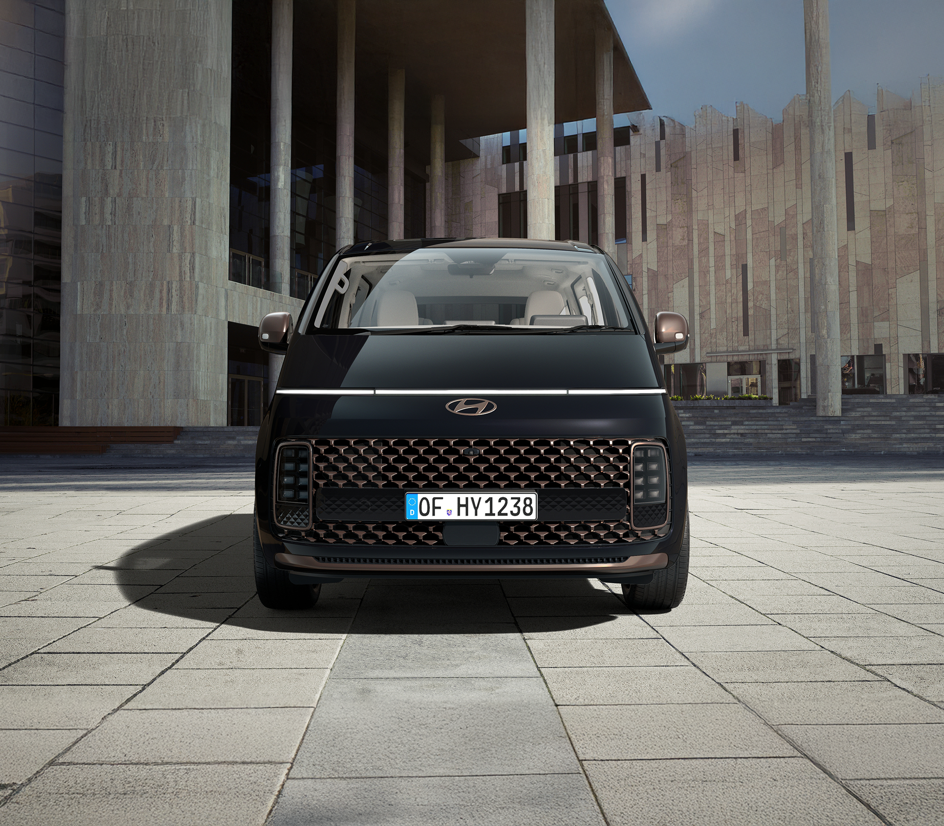 Hyundai Staria in schwarz von vorne mit einem modernen Hintergrund