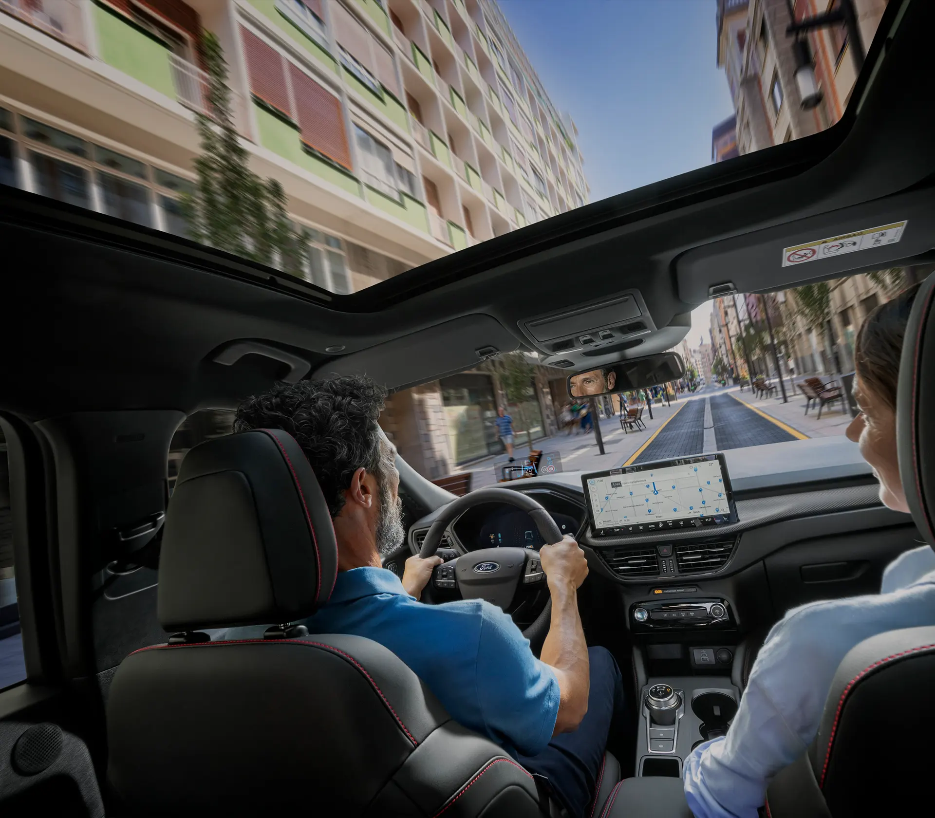 Mann und Frau sitzen im Kuga und fahren